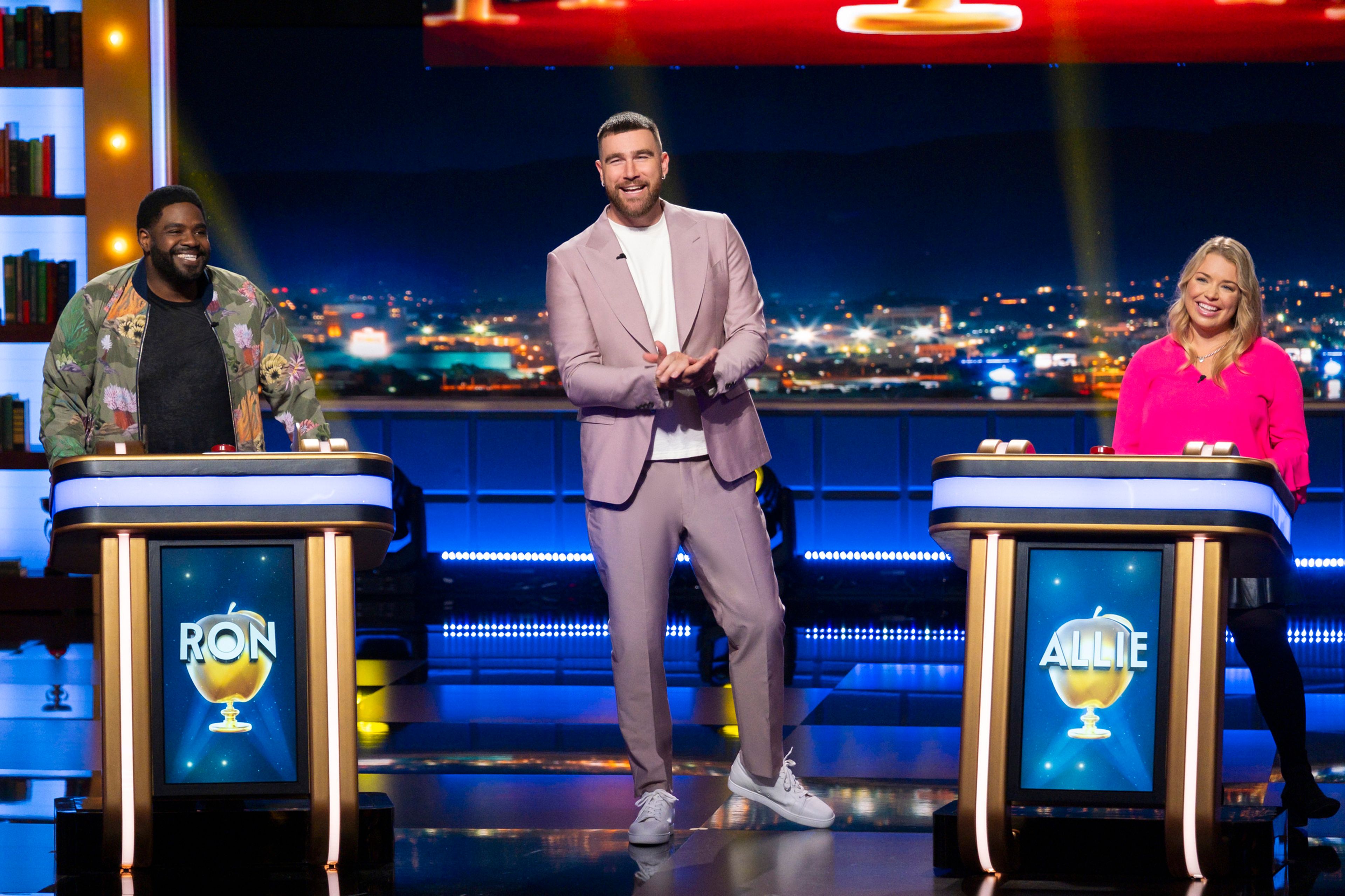 This image released by Prime Video shows NFL football player Travis Kelce, of the Kansas City Chiefs, center, hosting the new game show "Are You Smarter Than a Celebrity." (Adam Rose/Prime Video via AP)