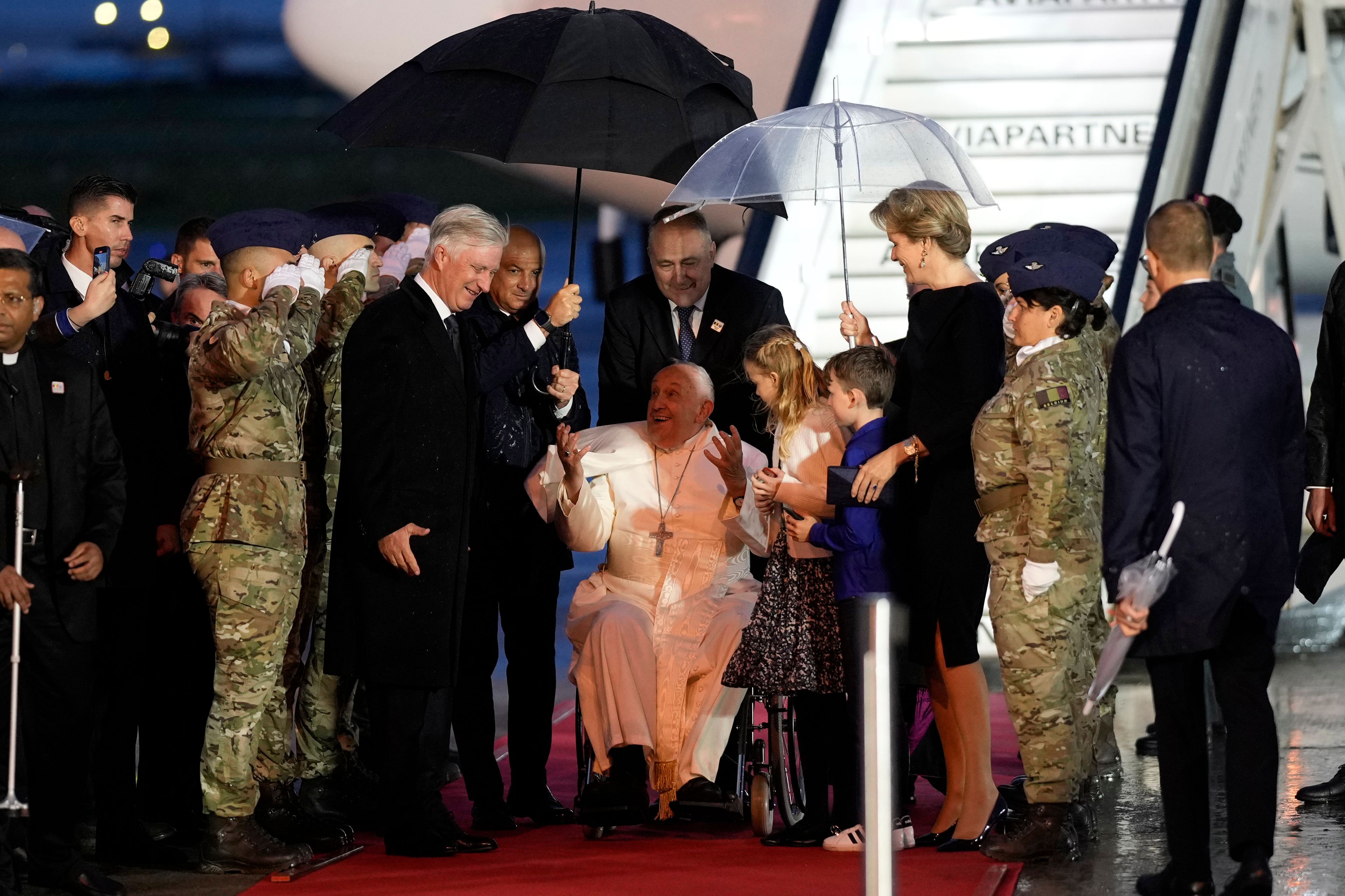 Pope Francis arrives flanked by Queen Mathilde of Belgium and King Philippe of Belgium at the Melsbroek air base in Steenokkerzeel, near Brussels, on the first day of his four-day visit to Luxembourg and Belgium, Thursday, Sept. 26, 2024. (AP Photo/Andrew Medichini)