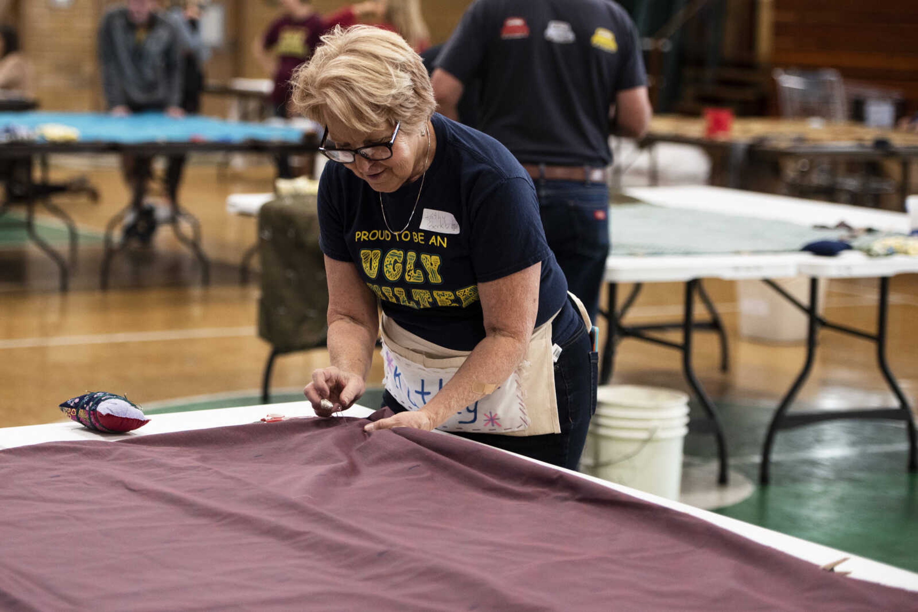 Kathy Berkbigler prepares a bed roll for tacking during the Ugly Quilt Weekend at St. Vincent de Paul Parish Sunday, Oct. 28, 2018, in Cape Girardeau.