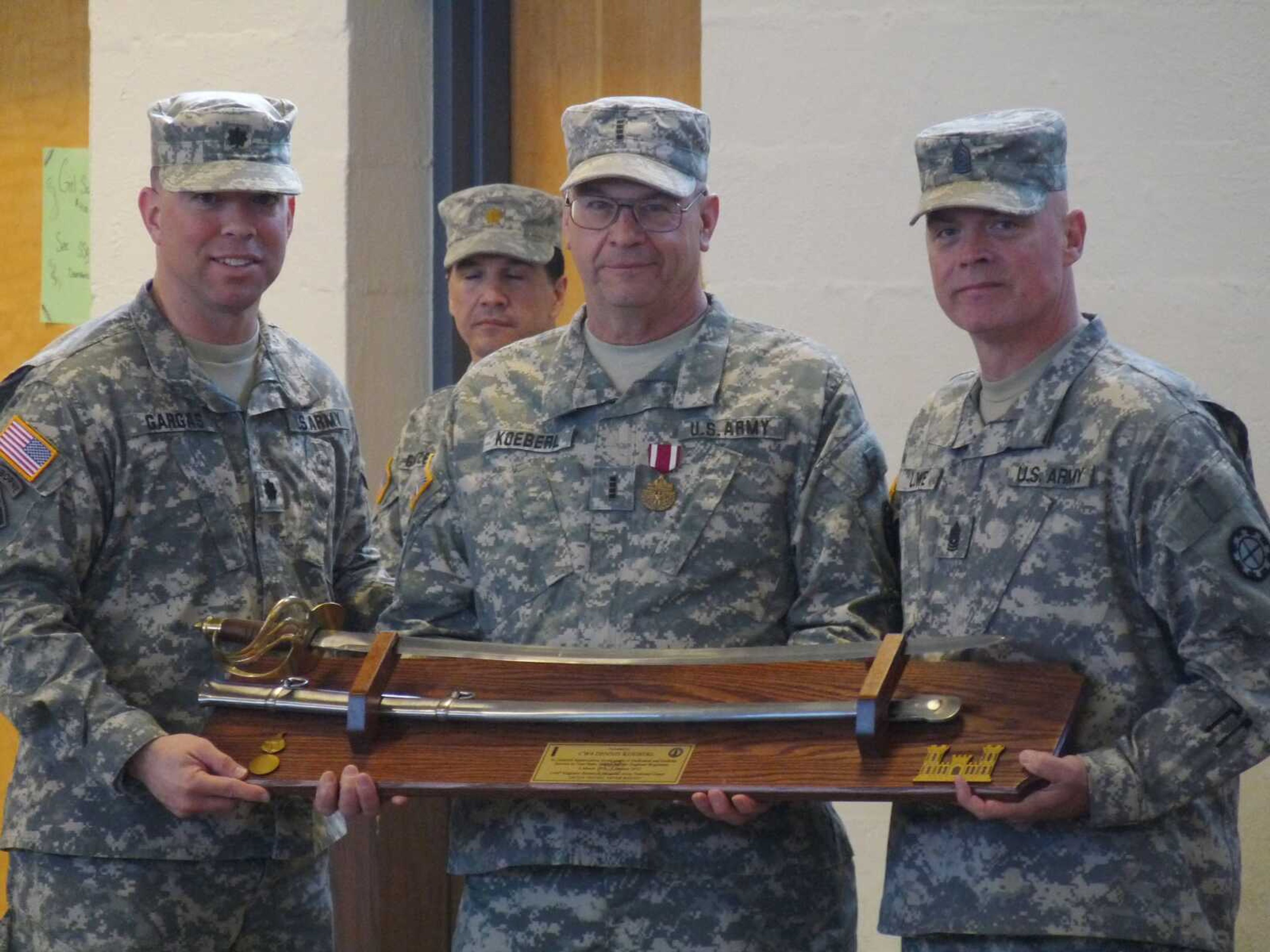 Lt. Col. Ed Gargas and Command Sgt. Maj. Tim Lowe, both of the 1140th Engineer Battalion, present Chief Warrant Officer 4 Dennis Koeberl the Legion of Merit award and an Officers Sword for the impact and contributions he made to the battalion, the Missouri National Guard and the U.S. Army during his 42-year service.