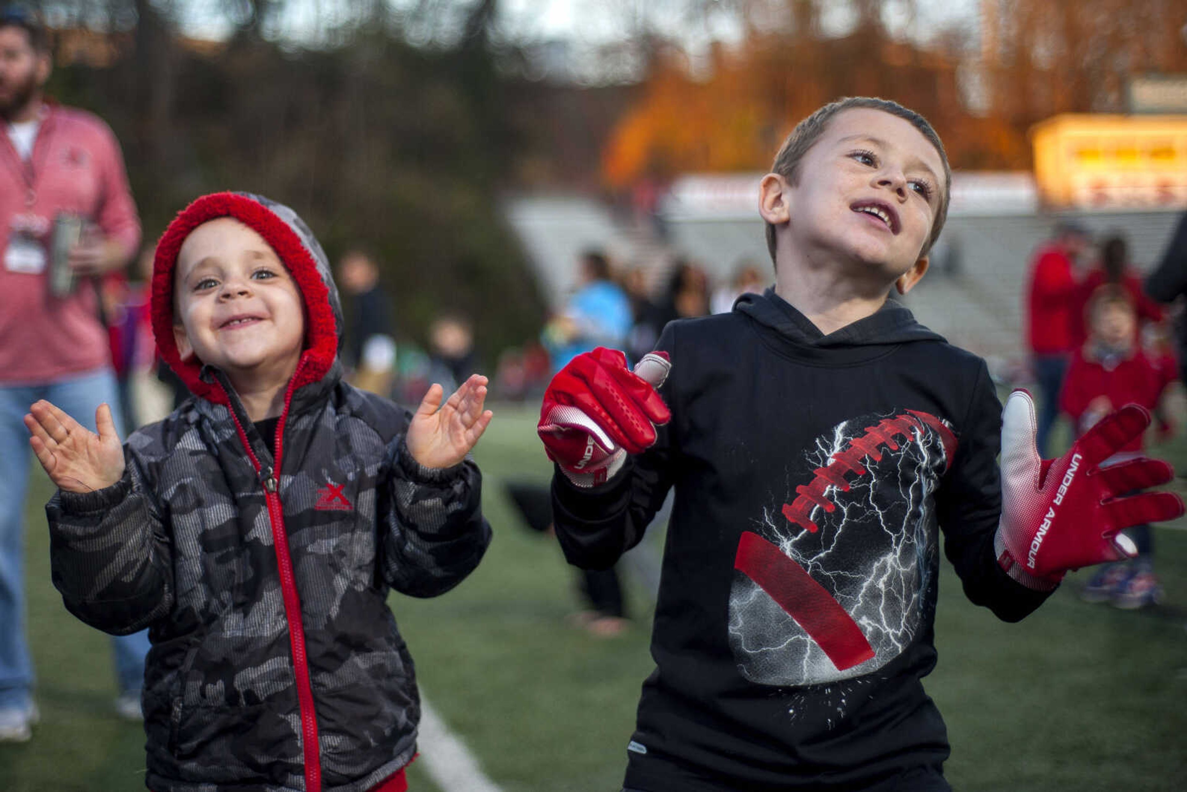 Kolbe Barke, 3, left, dances with his brother Jackson, 6, who had received a pair of gloves worn by wide receiver Kobe Bryer at Houck Stadium Saturday, Nov. 24, 2018.