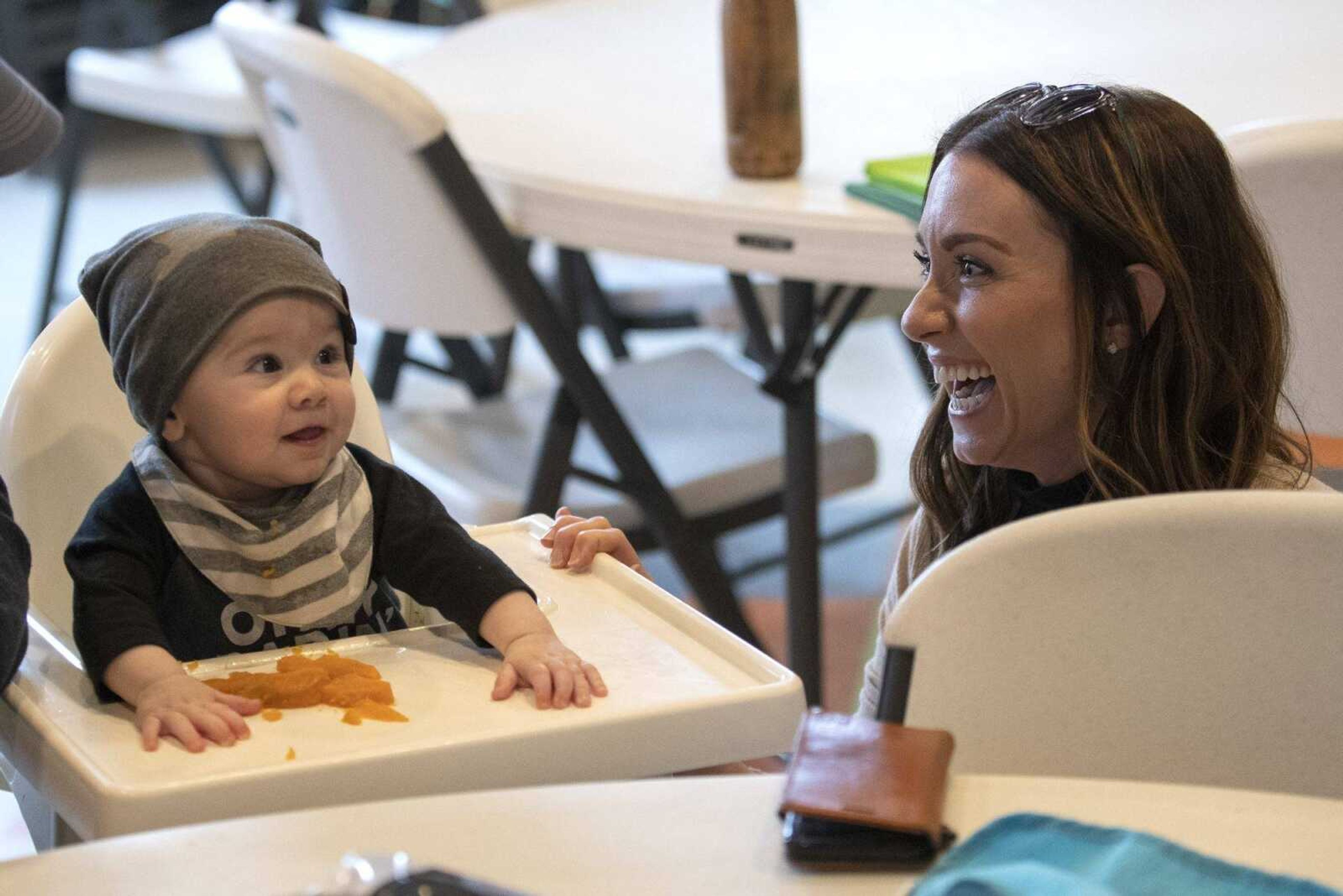 Declan Bear Cabral of Cape Girardeau, 6 months, smiles next to his mother, Sheri Cabral, while tasting sweet potatoes during a Baby's First Food Workshop led by registered dietitian Ellen Gipson of Cape Girardeau at Discovery Playhouse in Cape Girardeau on Feb. 23.