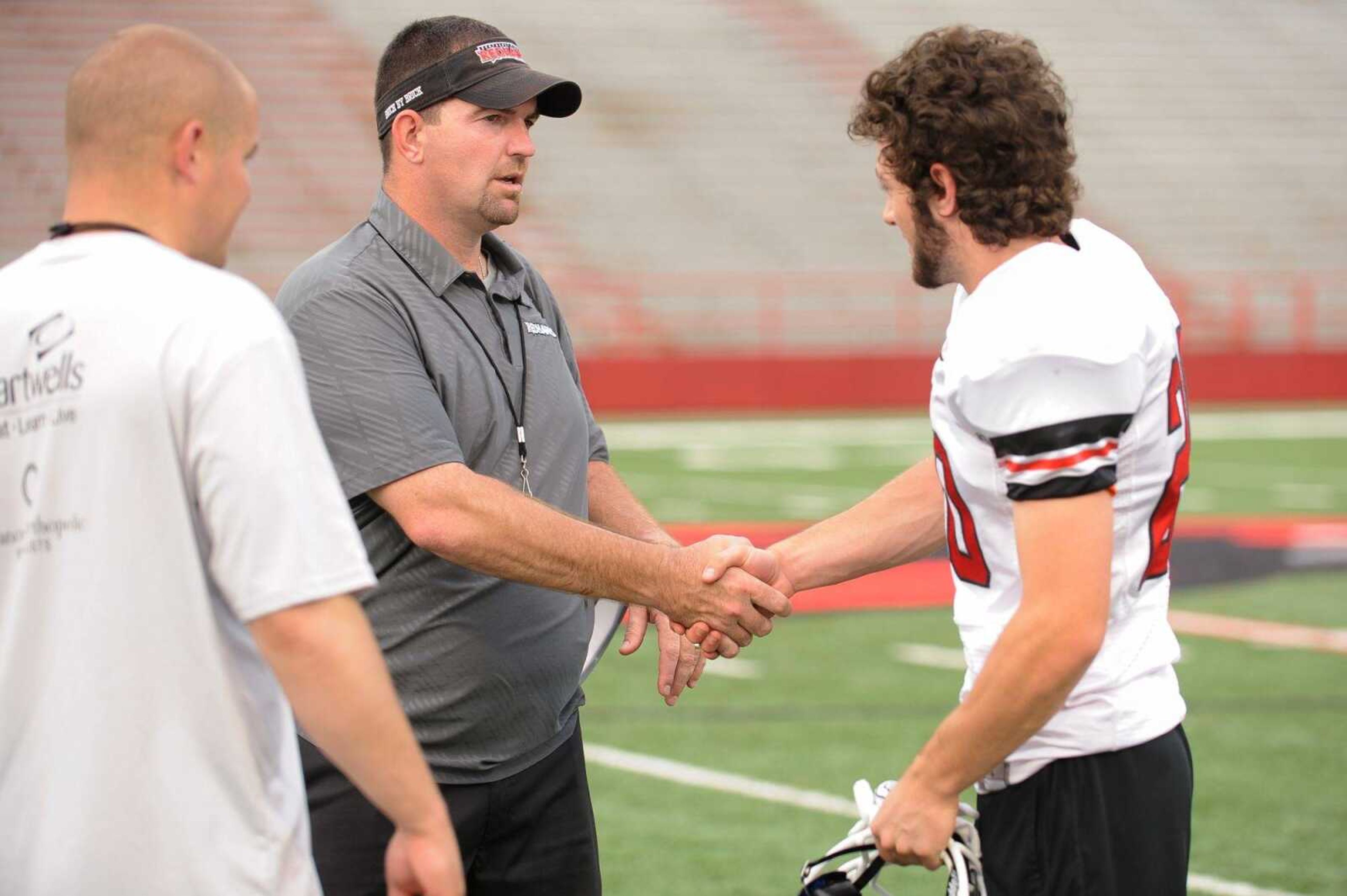 GLENN LANDBERG ~ glandberg@semissourian.com      Southeast Missouri State University coach  Tom Matukewicz meets with Seth Hedrick during a football prospect camp at Houck Stadium, Friday, June 5, 2015.