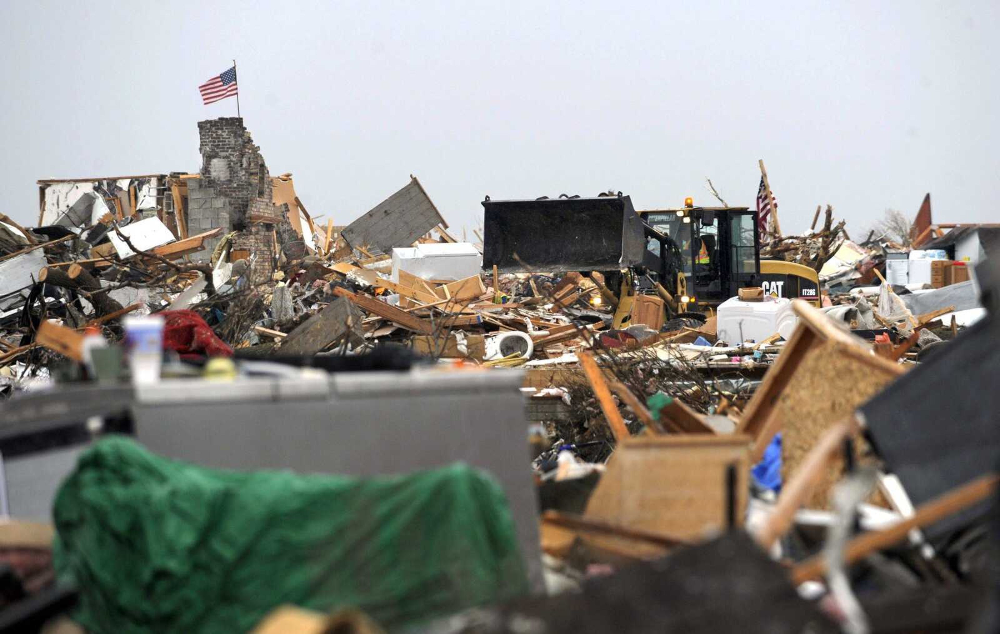 An endloader moves through debris covering the landscape of what was once a Washington, Ill., neighborhood on Thursday. (AP Photo/Journal Star, David Zalaznik)