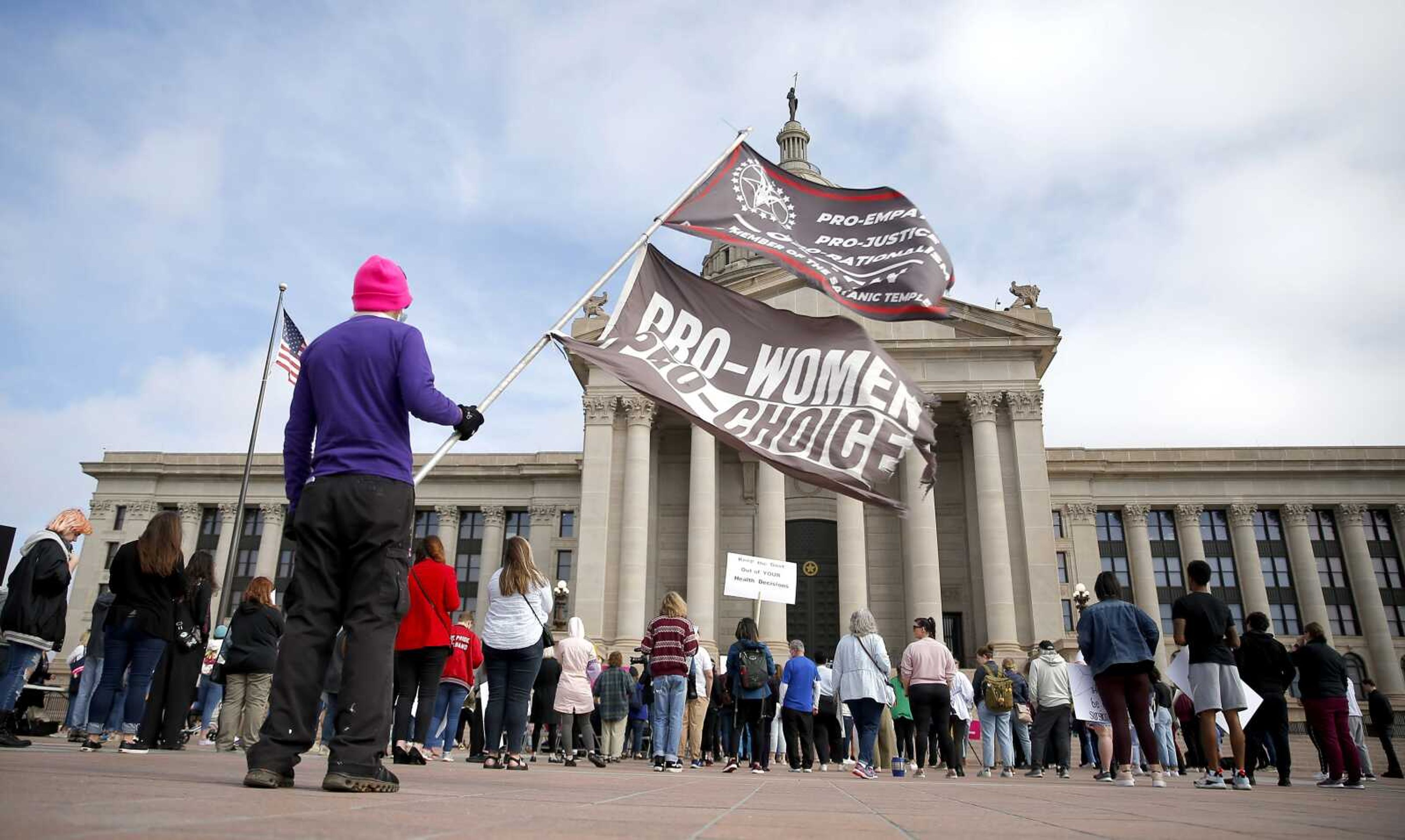 A person holds flags during the Bans Off Oklahoma Rally on the steps on Oklahoma state Capitol on April 5 in Oklahoma City. The Oklahoma House has given final approval to a Texas-style abortion ban prohibiting abortion after about six weeks of pregnancy.