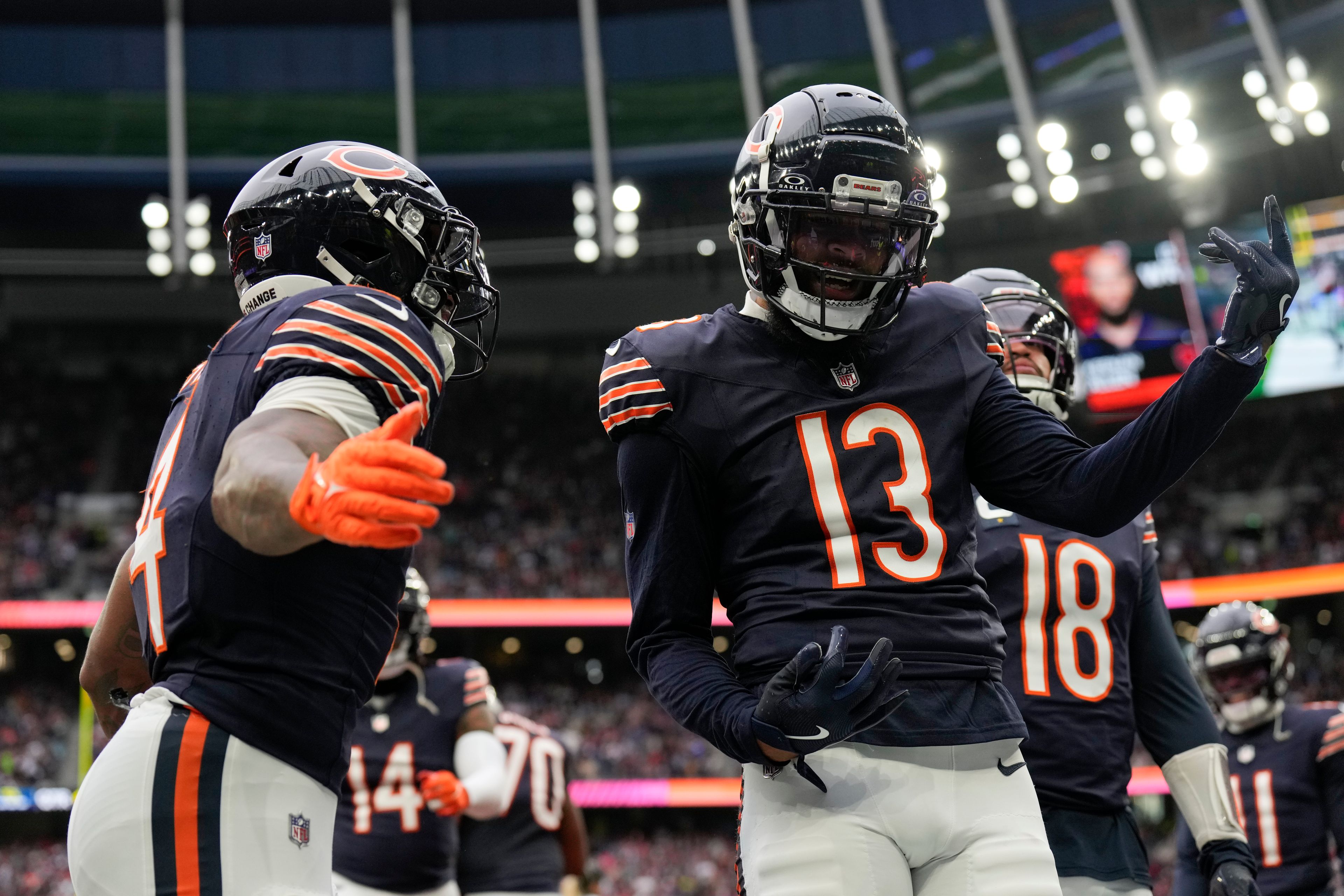 Chicago Bears wide receiver Keenan Allen (13), right, celebrates scoring a touchdown during the fourth quarter of an NFL football game at the Tottenham Hotspur stadium between the Jacksonville Jaguars and Chicago Bears in London, Sunday, Oct. 13, 2024.(AP Photo/Steve Luciano)