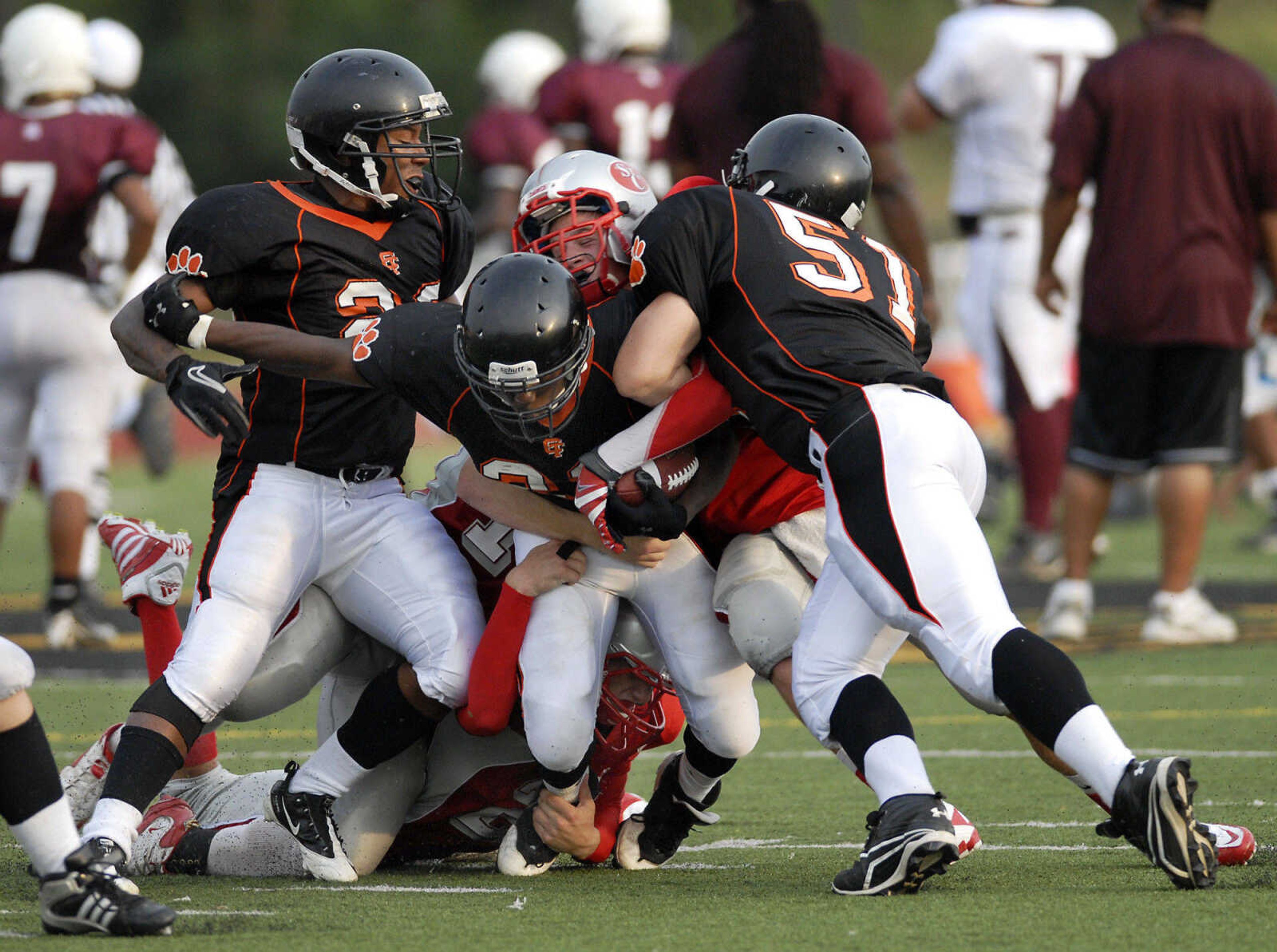 KRISTIN EBERTS ~ keberts@semissourian.com

Cape Central's Deonte Jenkins, center, gets tackled by St. Clair defenders during a jamboree game on Friday, August 20, 2010, at Farmington High School.