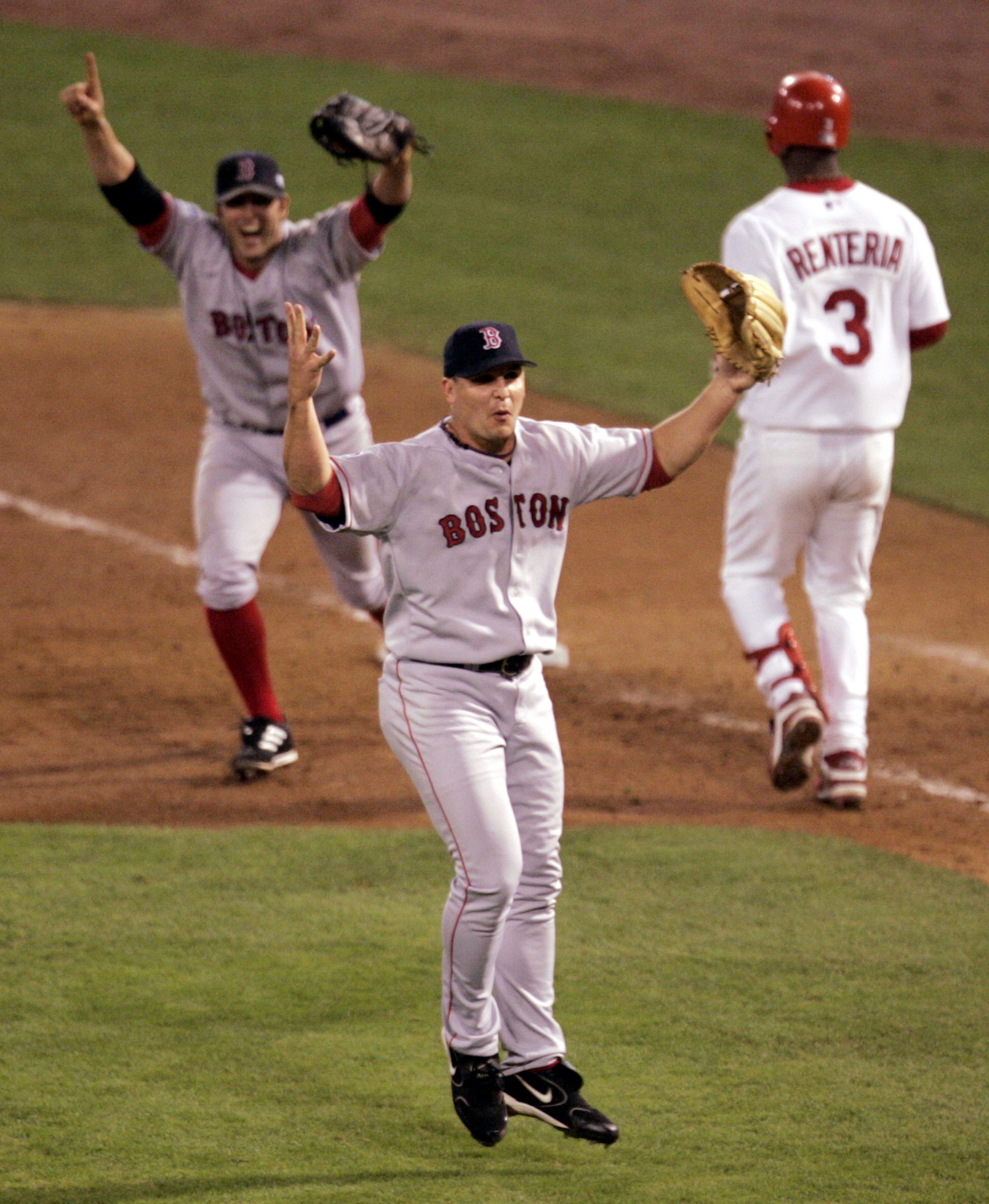 In this Oct. 27, 2004 file photo Boston Red Sox pitcher Keith Foulke, center, and first baseman Doug Mientkiewicz, left, celebrate after St. Louis Cardinals' Edgar Renteria (3) grounded out to end the ninth inning and give Boston a 3-0 win and a sweep of the World Series in St. Louis. The Red Sox won their first World Series since 1918 and breaking the "Curse of the Babino." 