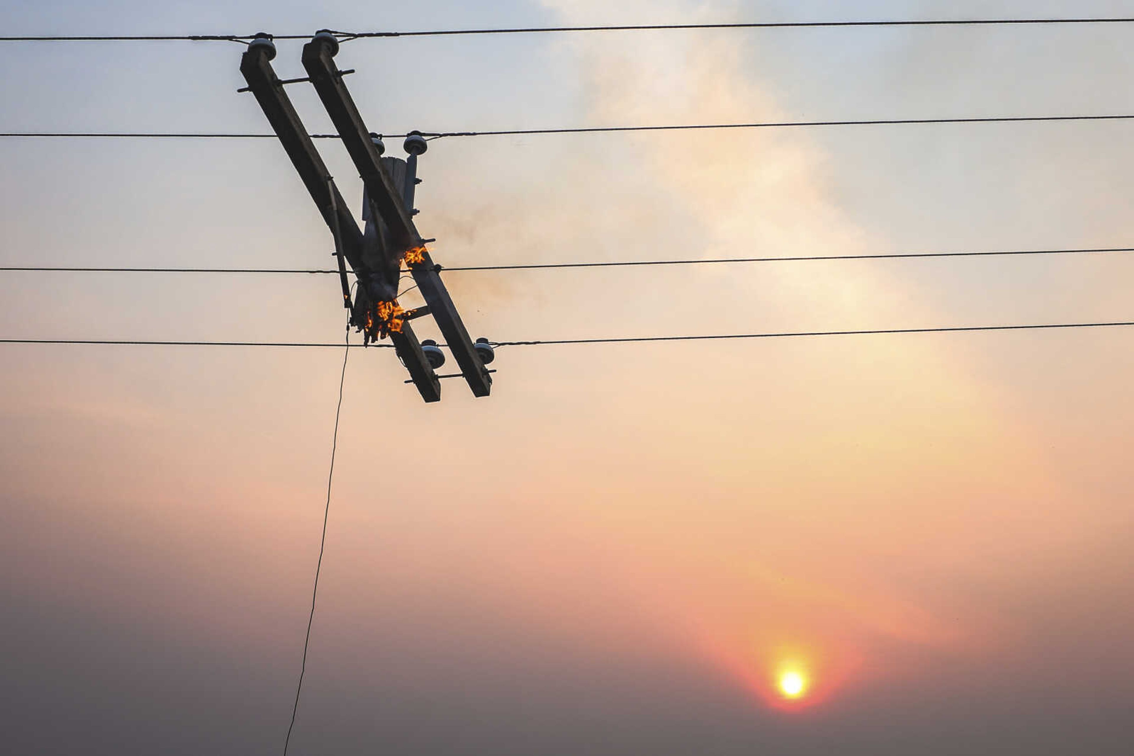 A telephone pole burns from the Smokehouse Creek Fire as the sun sets, Wednesday, Feb. 28, 2024, in Canadian, Texas. (AP Photo/David Erickson)