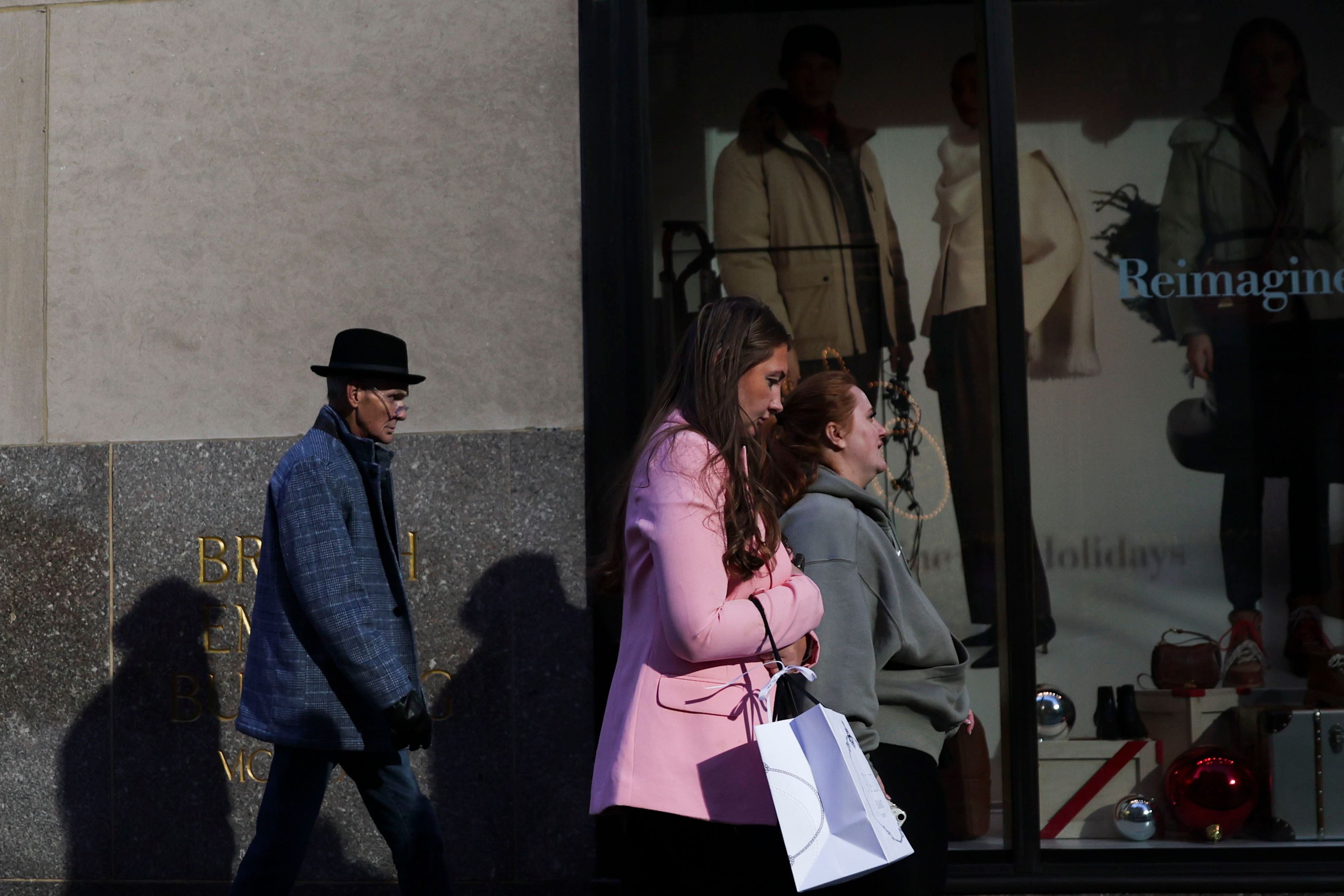 People shop as they walk along Fifth Avenue, Friday, Nov. 29, 2024, in New York. (AP Photo/Heather Khalifa)