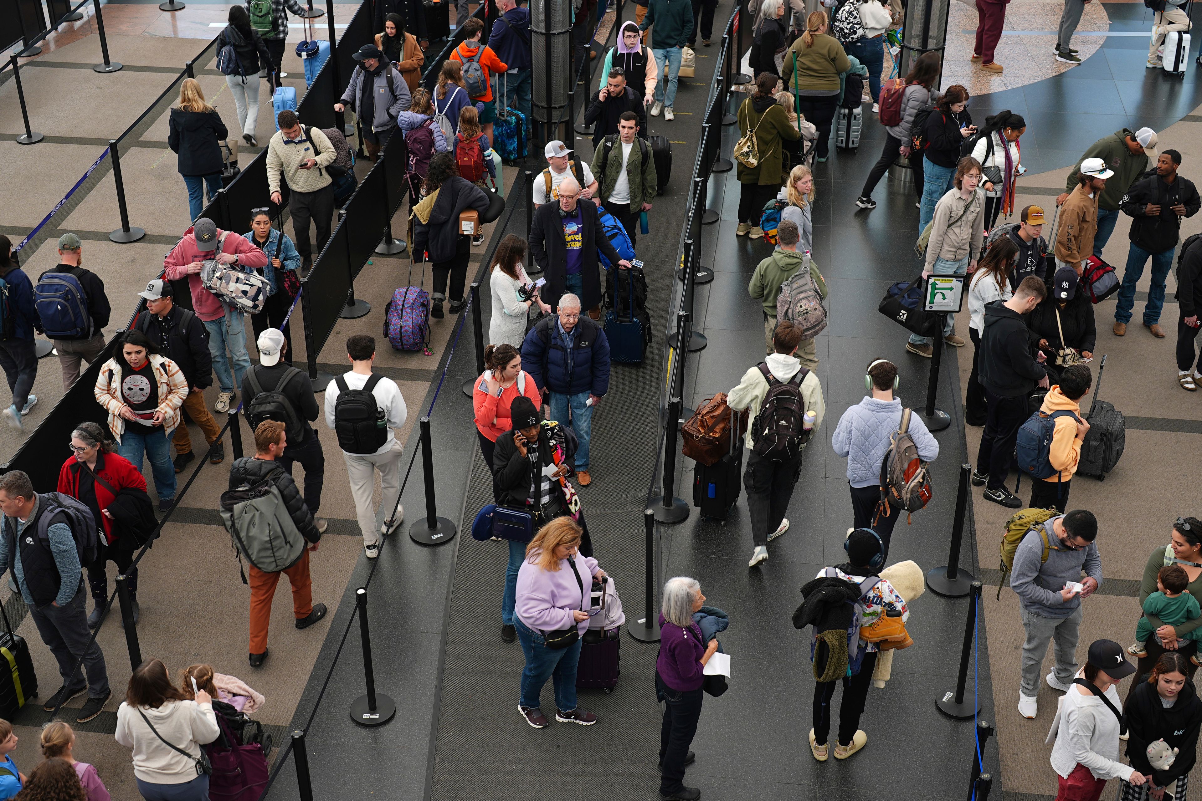 Travelers wade through a long line to pass through the south security checkpoint in Denver International Airport Tuesday, Nov. 26, 2024, in Denver. (AP Photo/David Zalubowski)