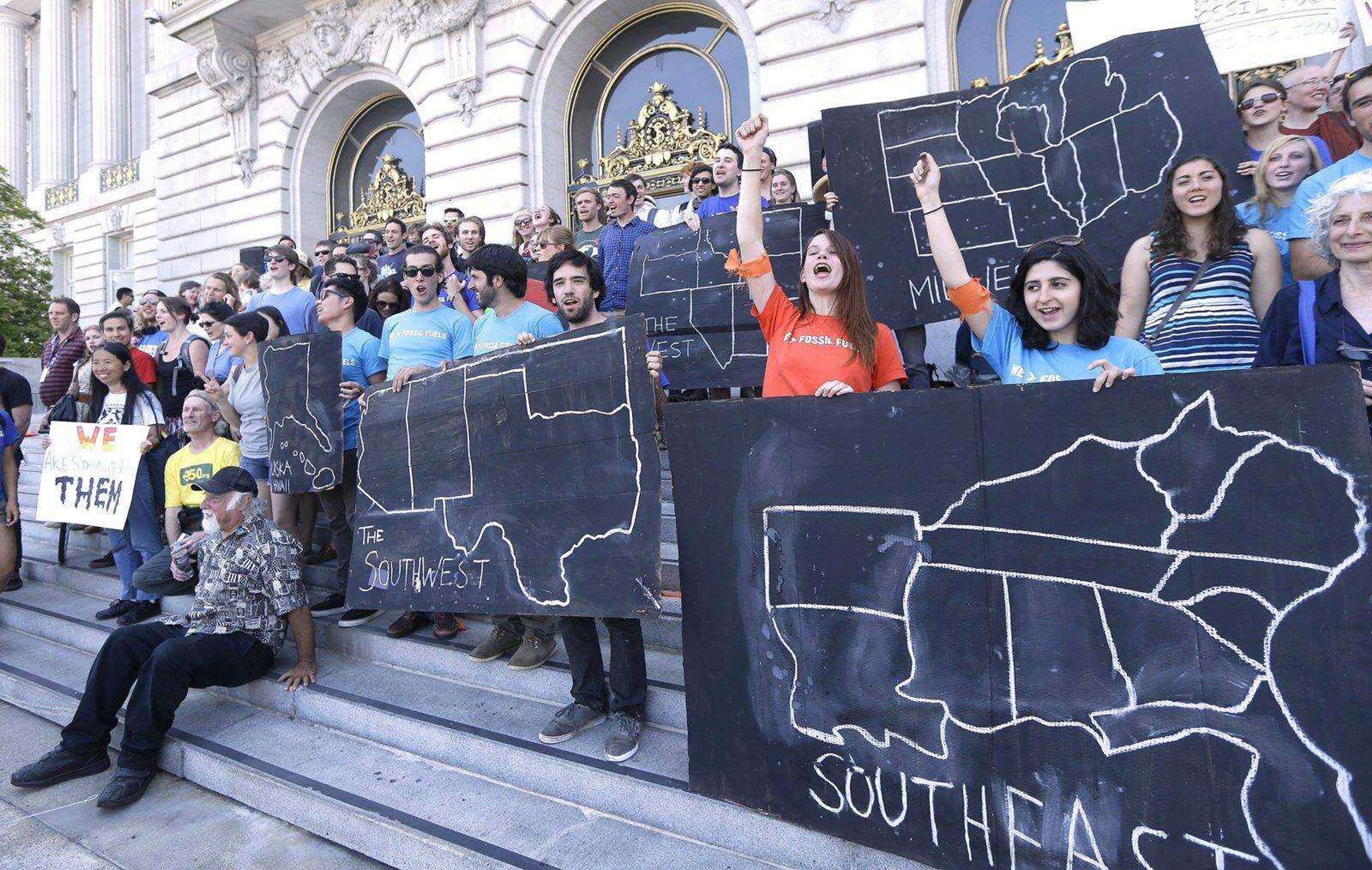 College students and supporters hold up signs at a rally to support fossil fuel divestment May 2 outside city hall in San Francisco. (Jeff Chiu ~ Associated Press)