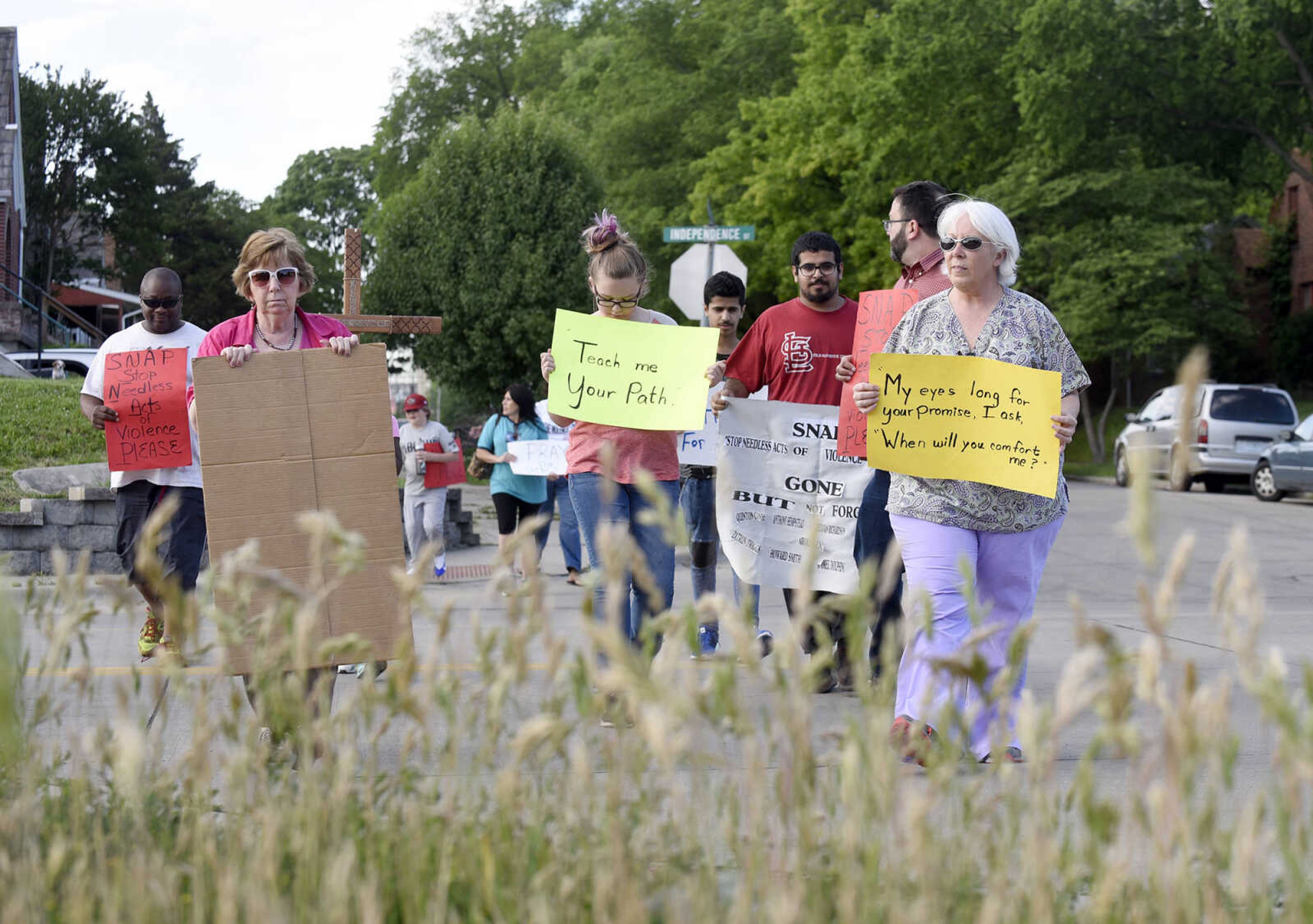 Community members join together in prayer during a Stop Needless Acts of Violence Please(SNAP) community prayer on Tuesday, May 16, 2017, at the corner of Independence Street and Henderson Ave. in Cape Girardeau.