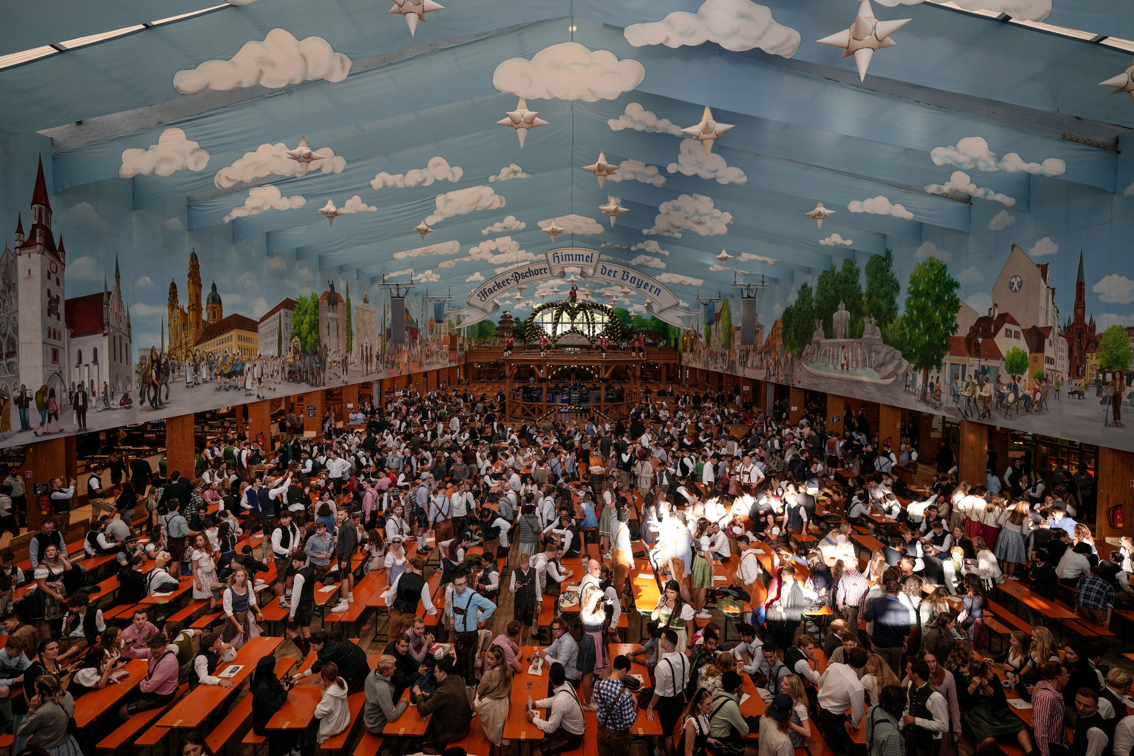 Visitors wait in the tent of the Hacker-Pschorr brewery, at the the start of the 189th 'Oktoberfest' beer festival in Munich, Germany, Saturday, Sept. 21, 2024. (AP Photo/Matthias Schrader)