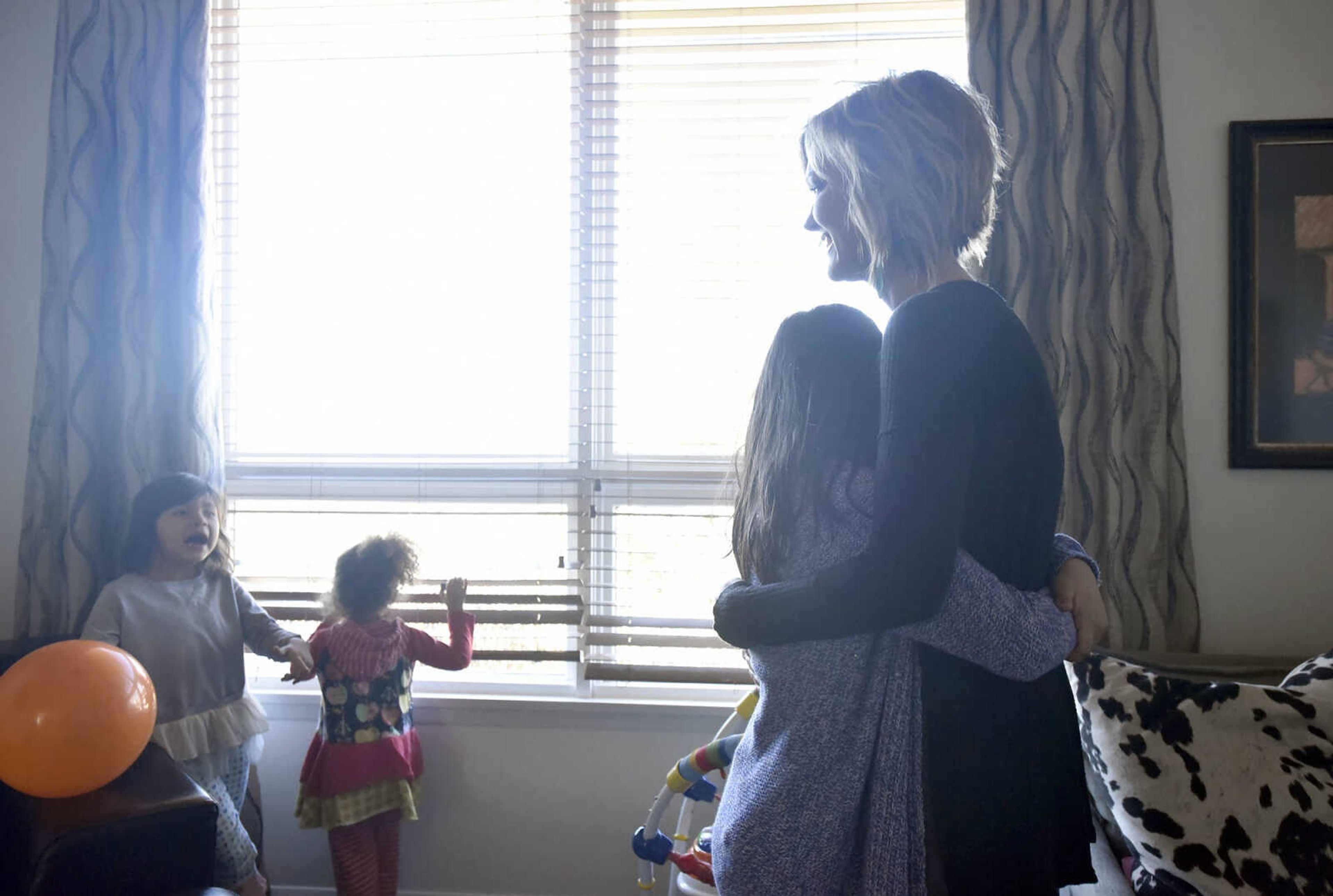 Bianca Becking, 10, hugs her mother, Chantelle, as they watch Ari, 5, left, and Dolly, 3, as they look out the window in the family room on Saturday, Jan. 28, 2017, at the Becking's Cape Girardeau home.