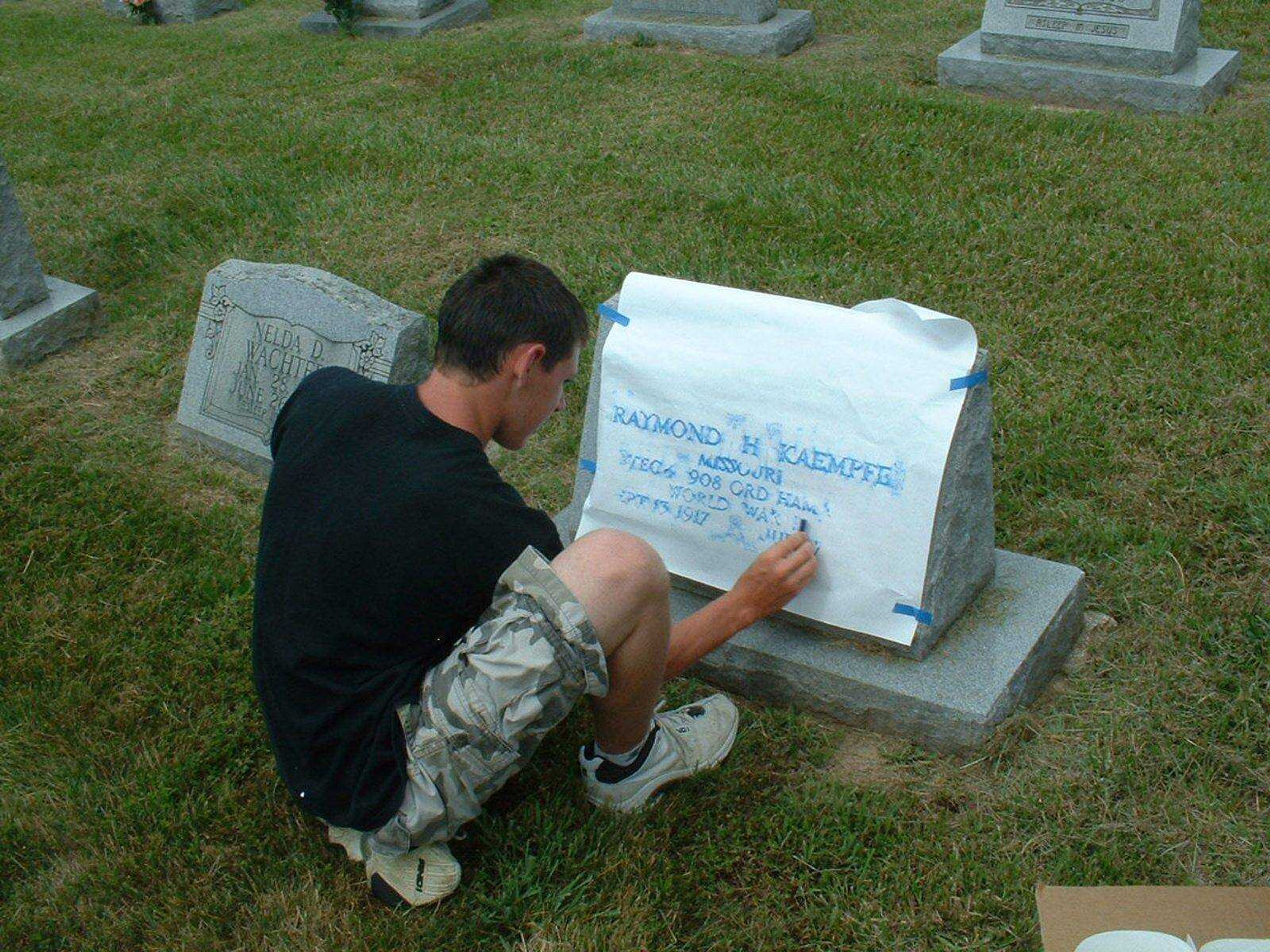 Lance Hoffman makes a rubbing of a headstone at Immanuel Lutheran Church's cemetery in New Wells (Submitted photo)