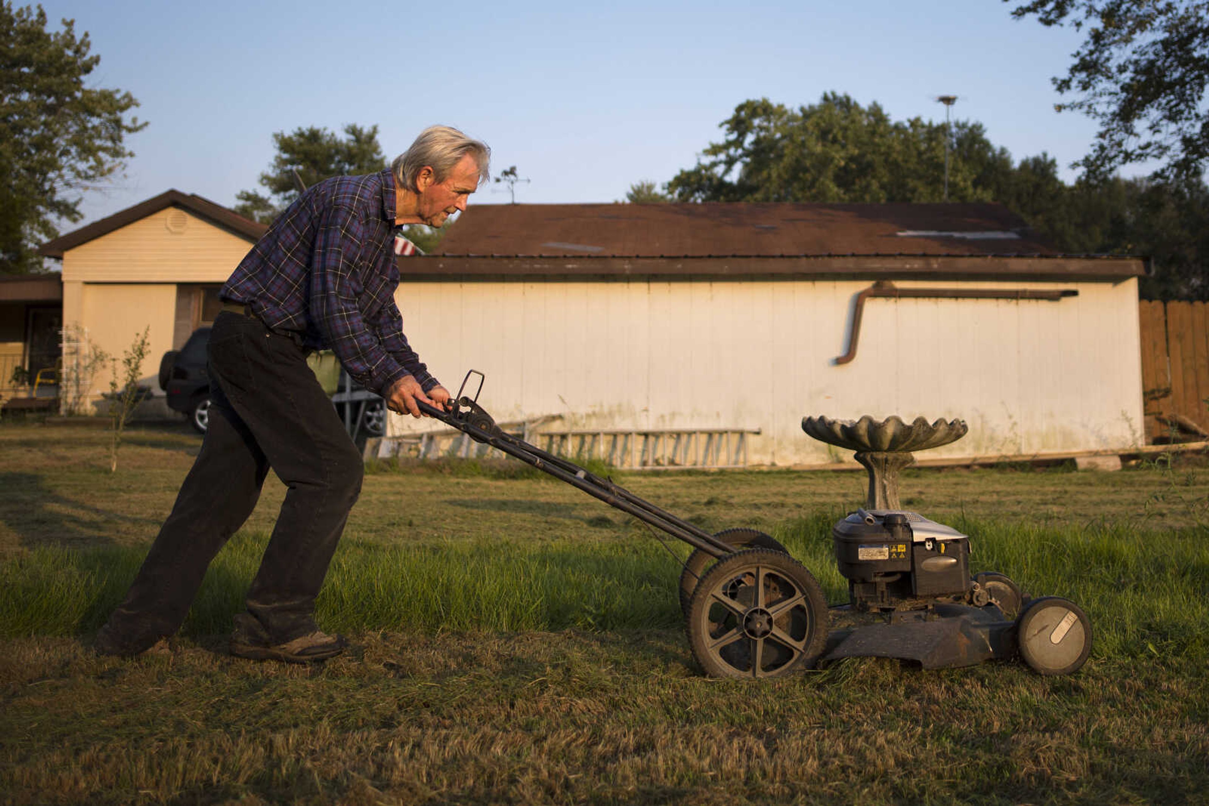 A man who asked to remain unidentified mows a lawn at dusk Wednesday, Sept. 11, 2019,&nbsp;near Olive Branch, Illinois.&nbsp;