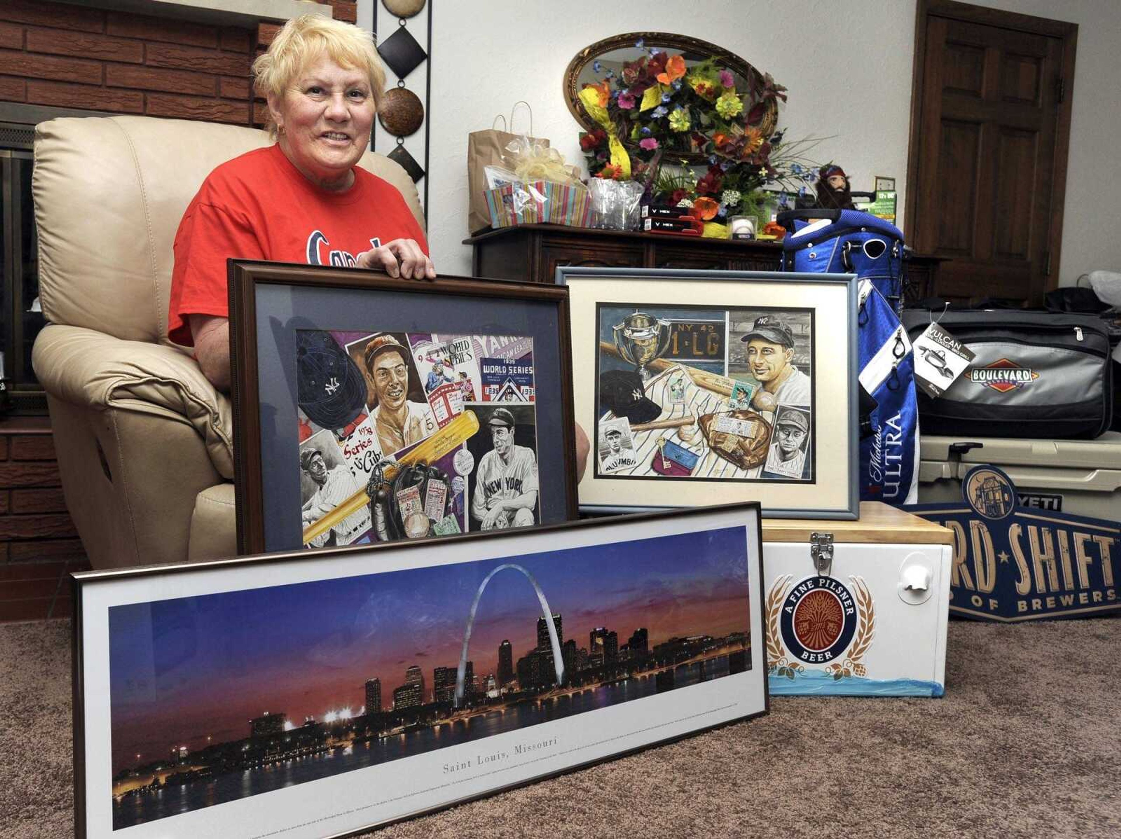 Mary Bolen shows a few of the items for the Capahas baseball auction to be held Friday at the Event Center of Isle Casino. Most of the money raised will fund the Capahas' trip to the National Baseball Congress World Series in Wichita, Kansas, later this month. (Fred Lynch)