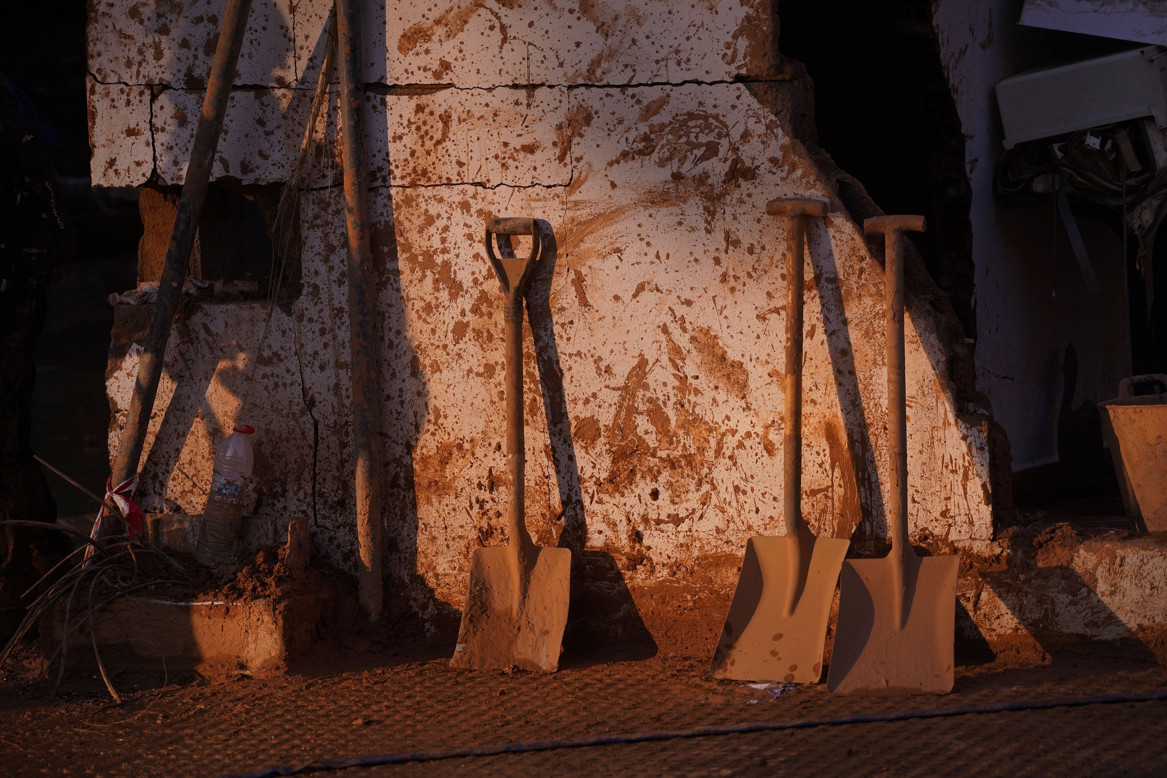 Shovels lean up against a wall during the clean up operation after flooding in Massanassa on the outskirts of Valencia, Spain, Wednesday, Nov. 6, 2024. (AP Photo/Alberto Saiz)