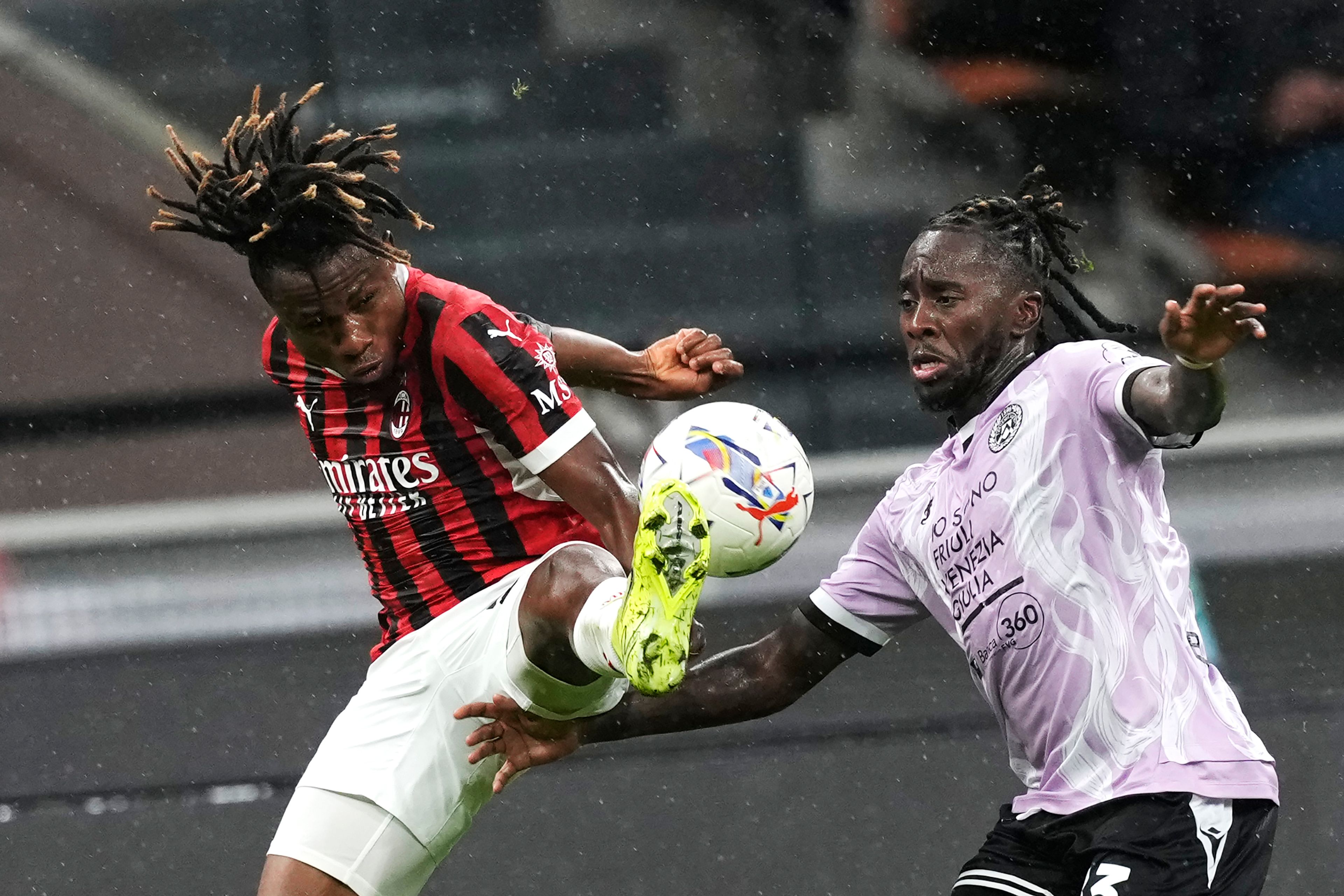 AC Milan's Samuel Chukwueze, left, and Udinese's Jordan Zemura challenge for the ball during the Serie A soccer match between AC Milan and Udinese at the San Siro Stadium, in Milan, Italy, Saturday, Oct. 19, 2024. (AP Photo/Antonio Calanni)