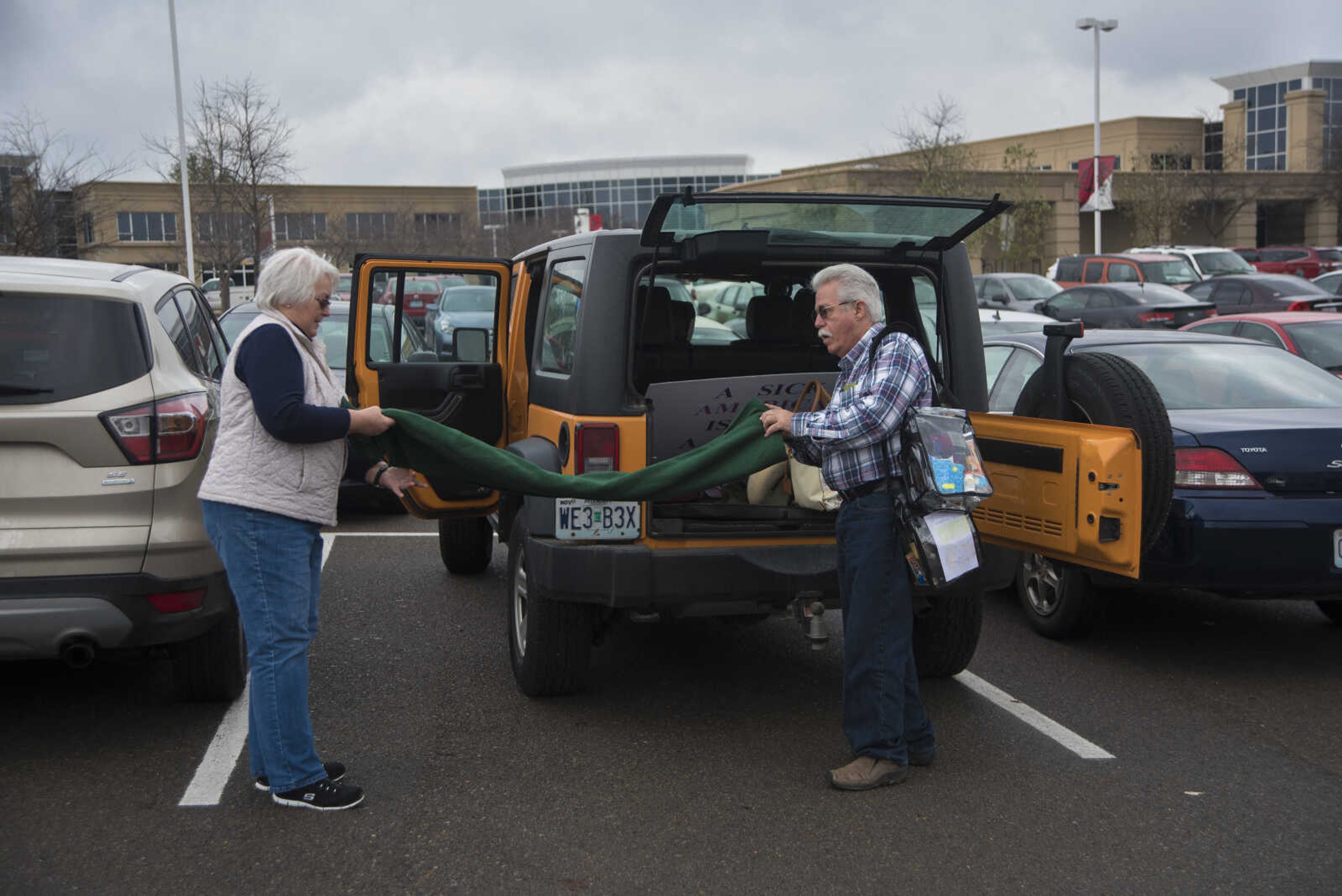 Marsha Smith, left, and her husband Herb Smith, right, unload their car to travel with others to Washington D.C. to participate in the Women's March on Saturday as they get ready to leave Friday, Jan. 20, 2017 in the Scully Building parking lot at Southeast Missouri State University in Cape Girardeau.