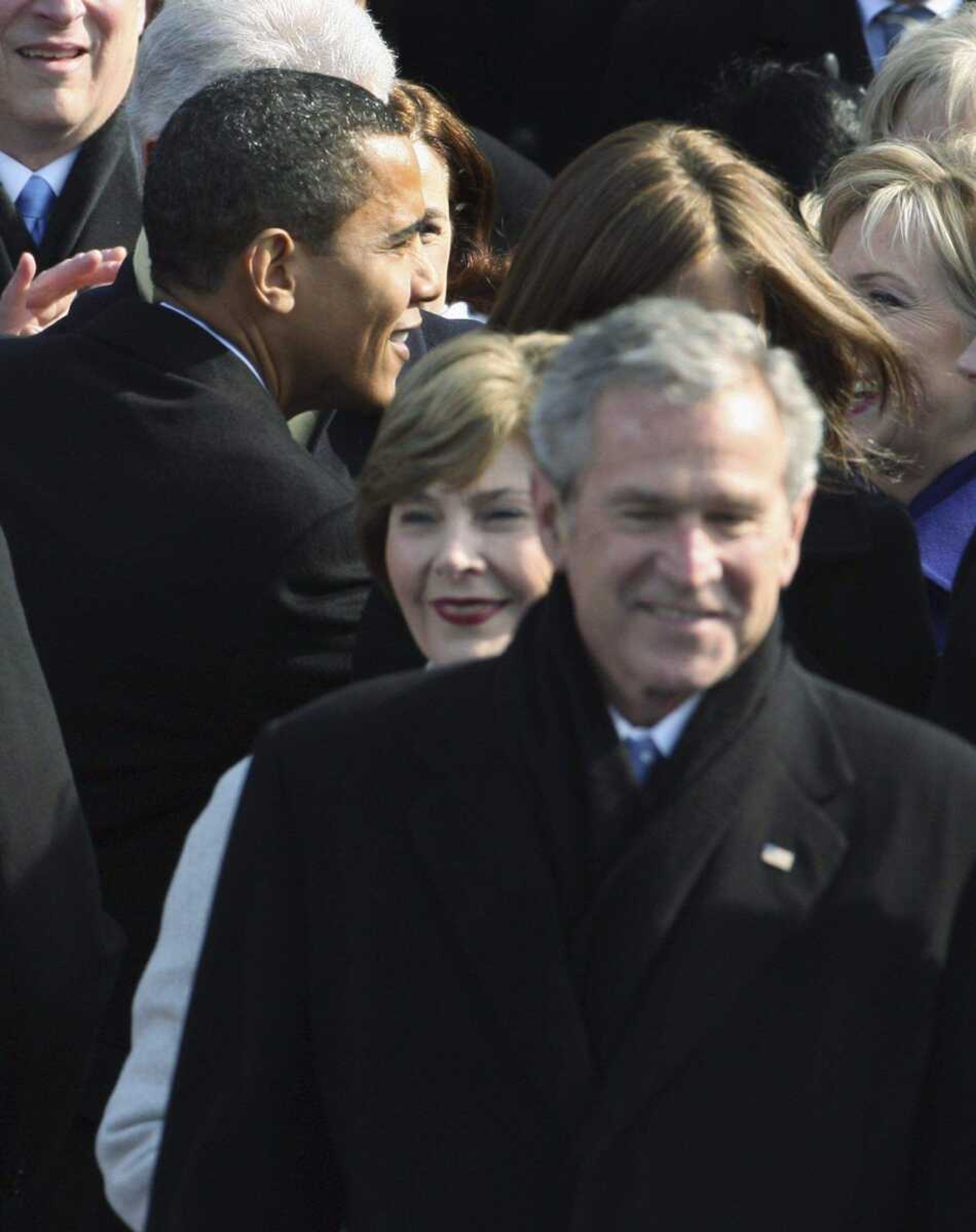 President George W. Bush and first lady Laura Bush walk to their seats as President-elect Barack Obama , background, is greeted as they arrive for swearing-in ceremonies at the U.S. Capitol in Washington, Tuesday, Jan. 20, 2009. (AP Photo/Ron Edmonds)