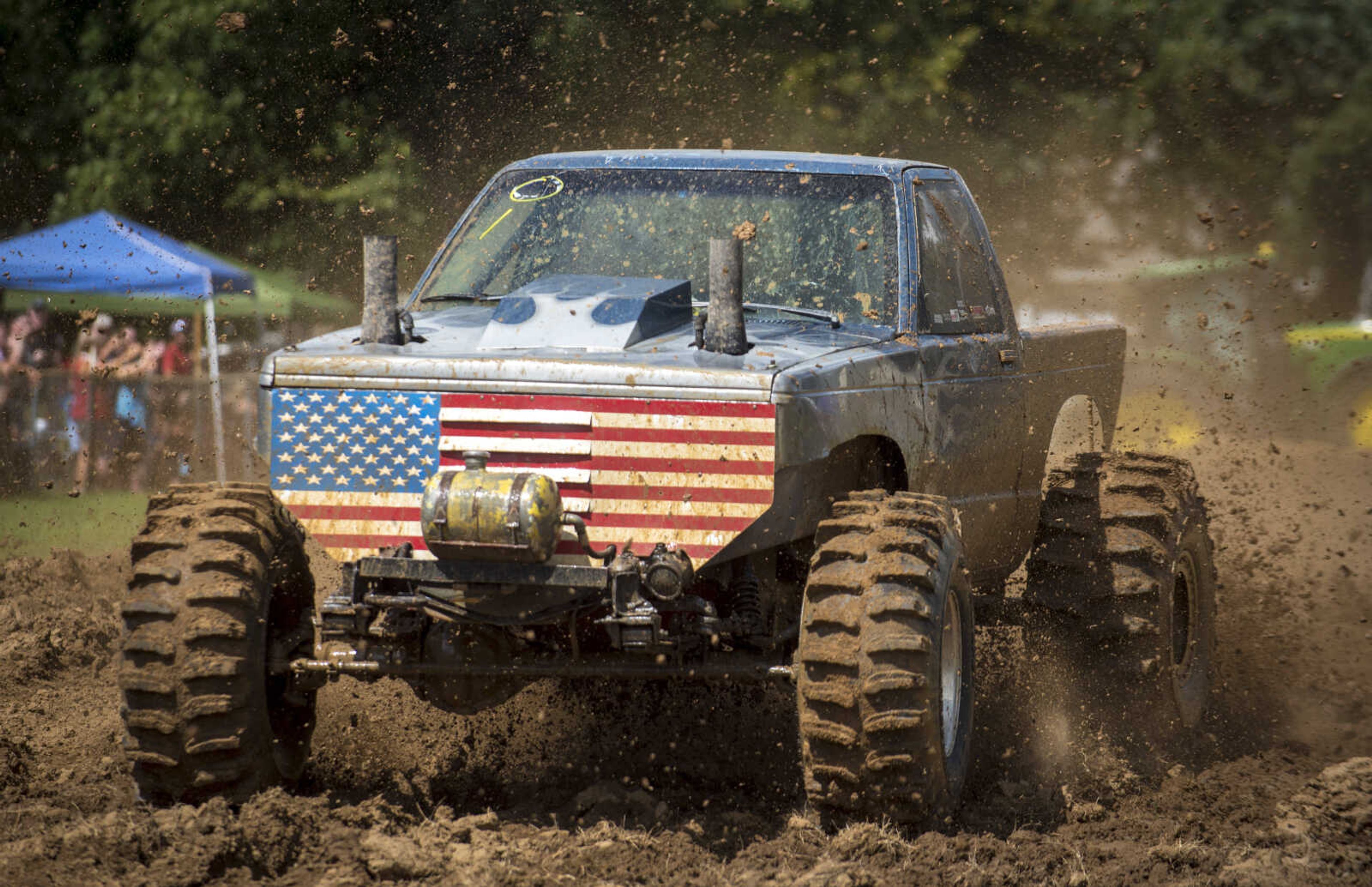 A truck flings mud as it heads down the racetrack during Benton Neighbor Days Saturday, September 1, 2018.