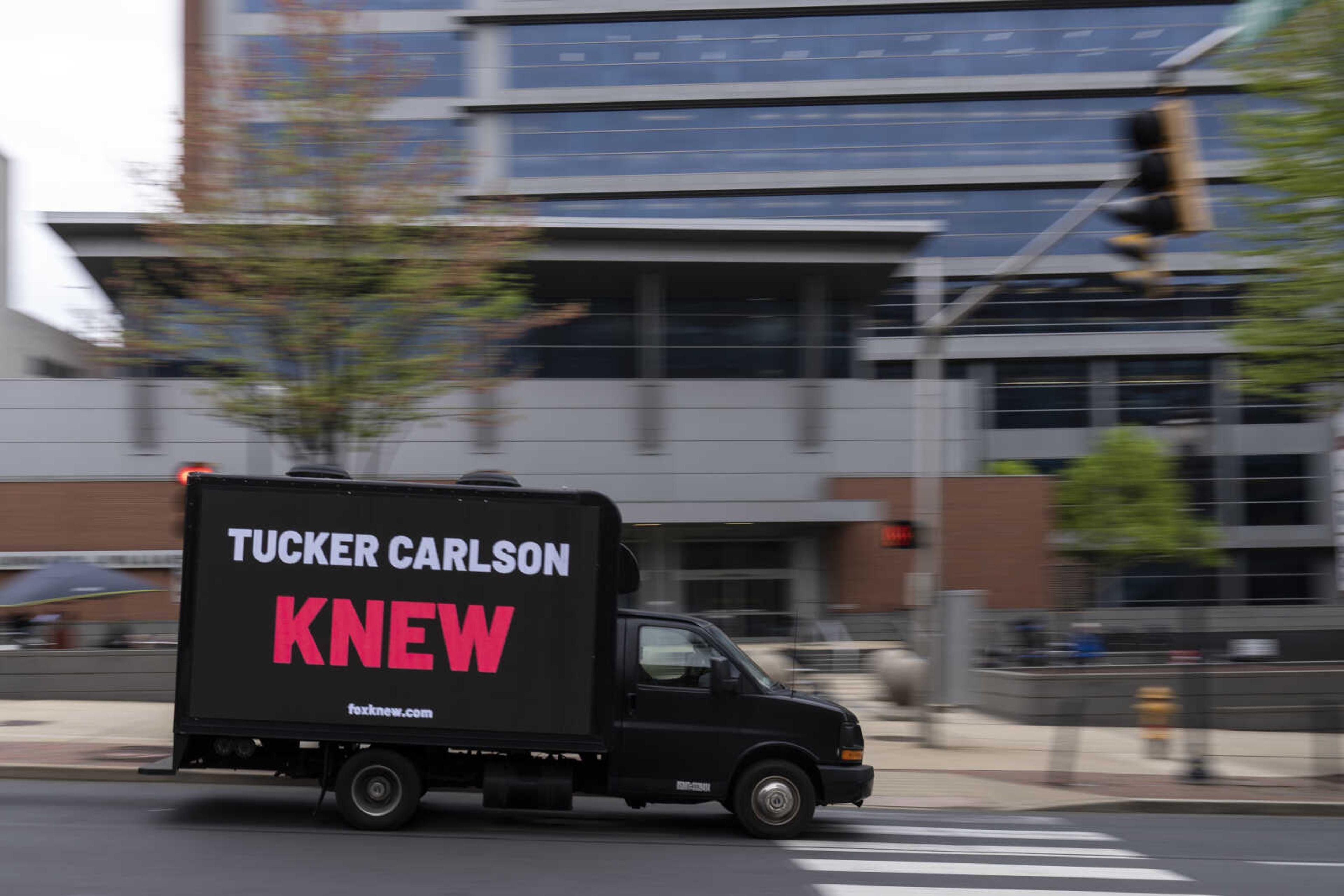 A protest vehicle drives past the justice center in Wilmington, Del., Monday, April 17, 2023, where the Dominion Voting Systems  defamation lawsuit against Fox News is set to take place. The Delaware judge overseeing the voting machine company s $1.6 billion lawsuit has announced a delay in the start of the trial until Tuesday, giving no explanation in announcing the recess. (AP Photo/Matt Rourke)