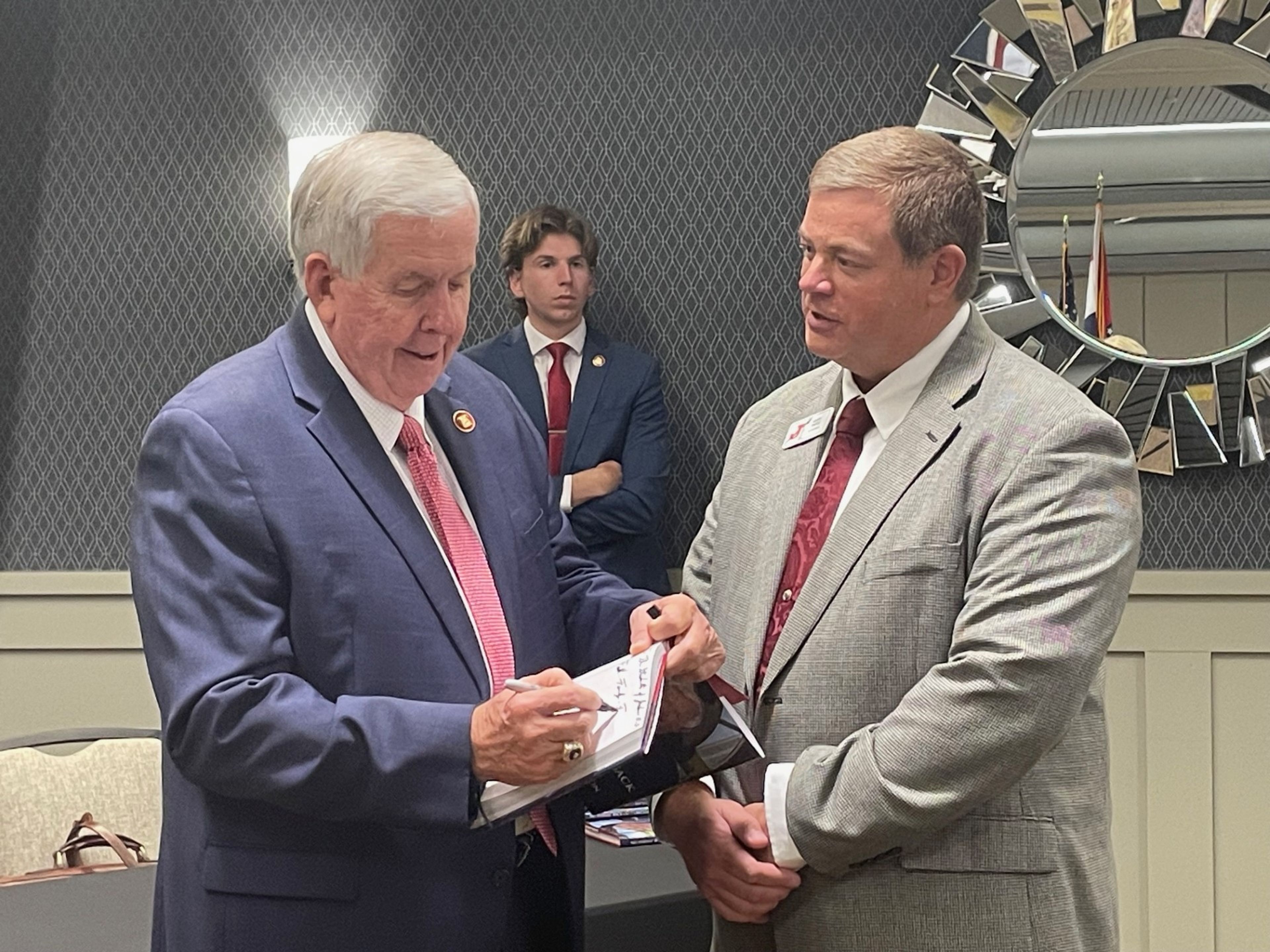 Missouri Governor Mike Parson, left, signs a copy of his biography No Turnin' Back for Jackson R-2 School District superintendent Scott Smith during the State of the Community Luncheon in Cape Girardeau on Thursday, Aug. 22. Parson spoke to an audience of hundreds about some of the business and infrastructure accomplishments he spearheaded during his six years in office.