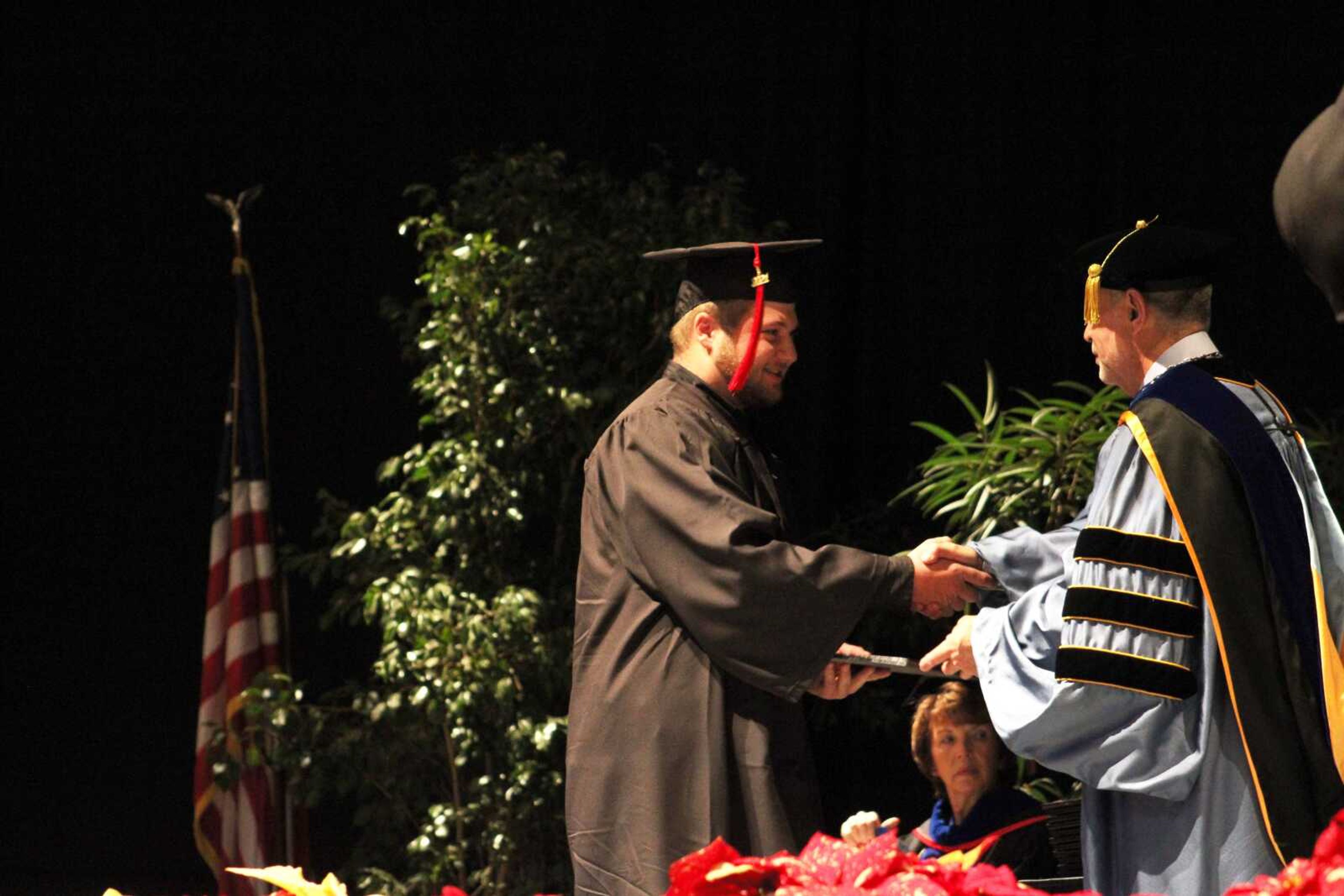 A Southeast Missouri State University graduate shakes hands with President Carlos Vargas while receiving his diploma during SEMO's afternoon Fall Commencement Ceremony Saturday, Dec. 18, 2021, at the Show Me Center in Cape Girardeau.