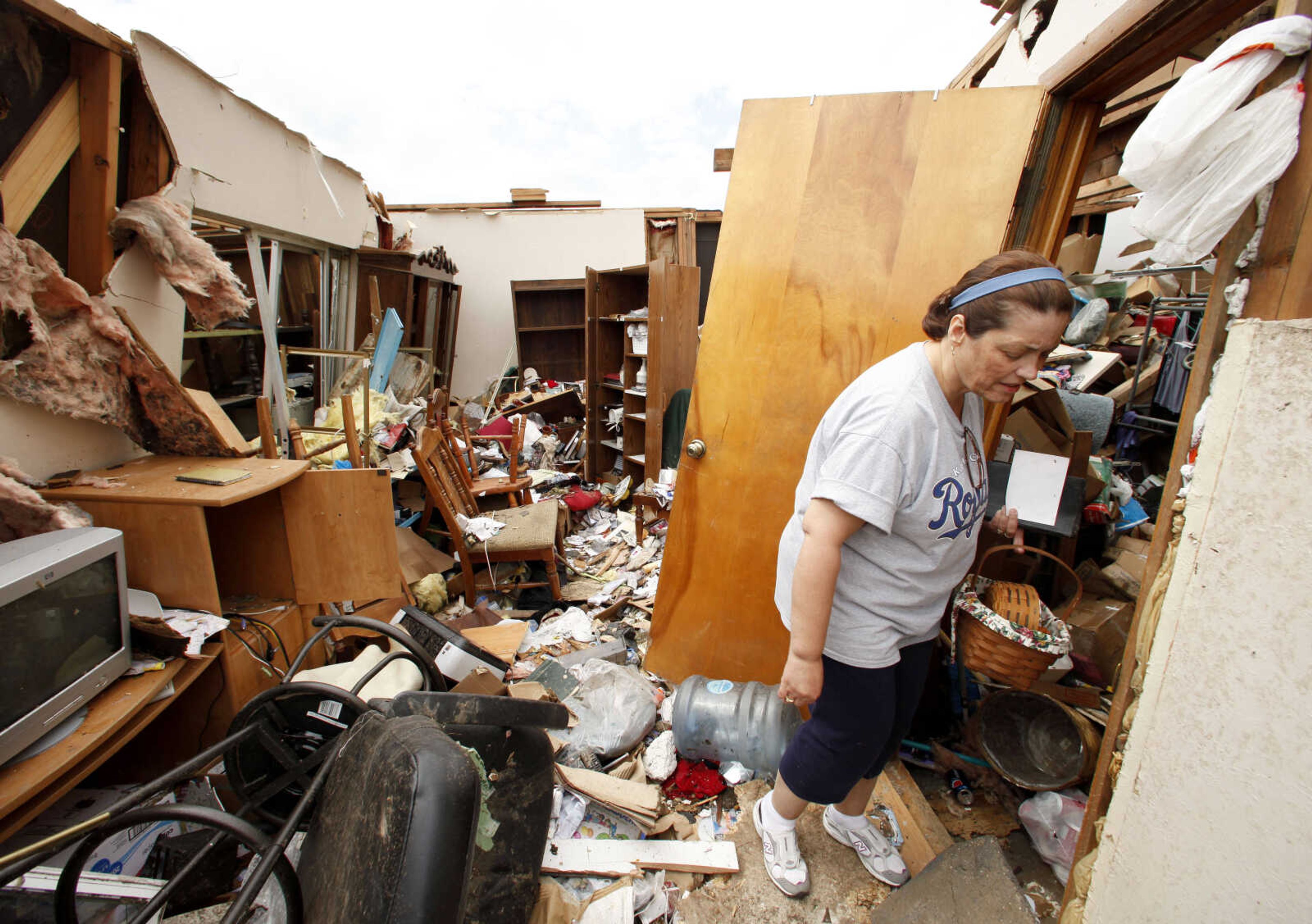 Lisa Lawrence salvages items from her parents' devastated home in Joplin, Mo. Wednesday, May 25, 2011. An EF-5 tornado tore through much of the city Sunday, damaging a hospital and hundreds of homes and businesses and killing at least 123 people. (AP Photo/Charlie Riedel)