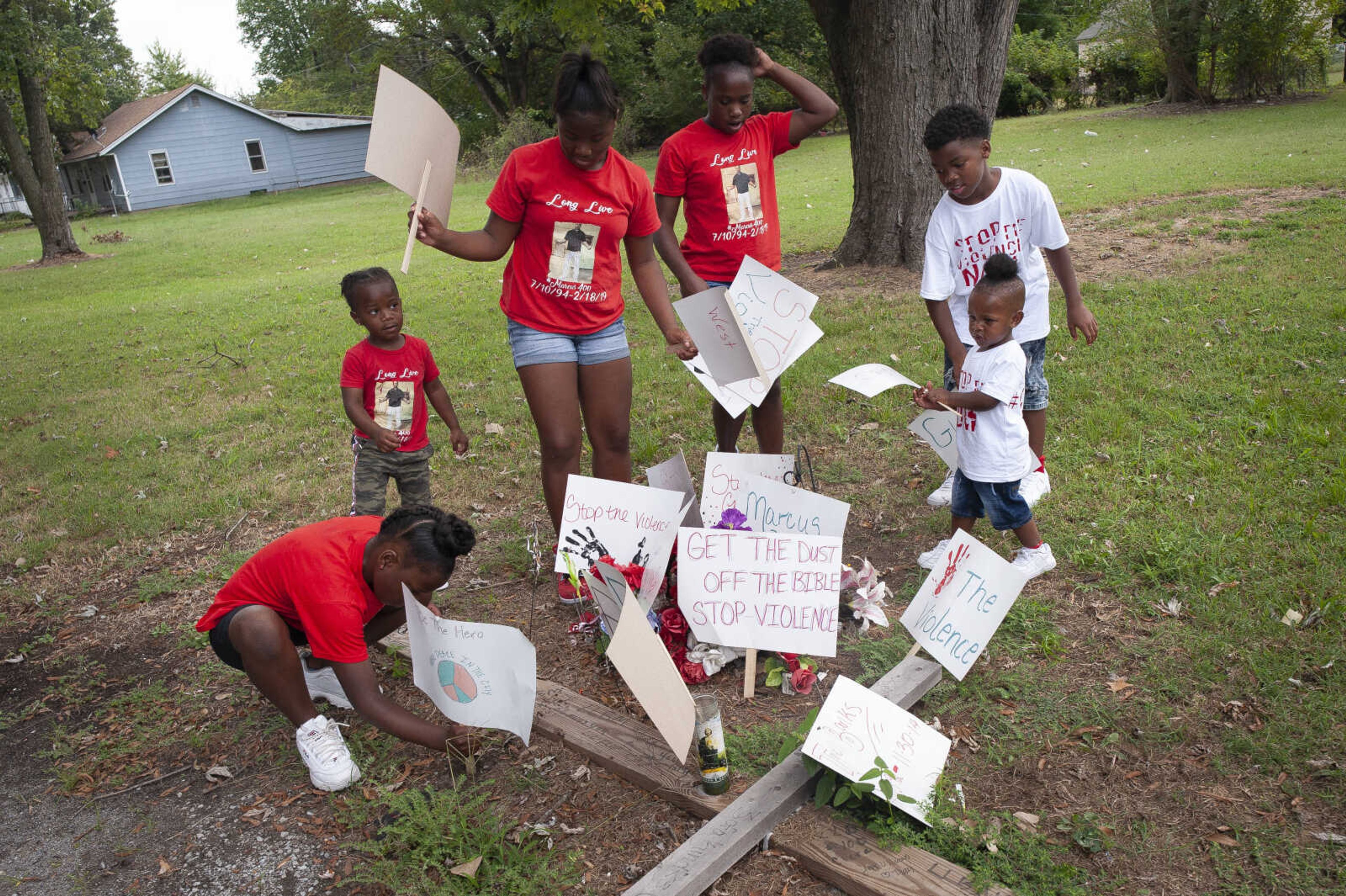 The family of the late Marcus Dixon Jr. of Sikeston from left: cousin Johnnyla Jones, 8; cousin Bryce Brown, 3; cousin Destiny Brown, 11; cousin Ajaevia Mitchell, 12; stepson Naquavion Allen, 9; and son Kayden Dixon, 2; place signs, used in a "Stop the Violence" march earlier in the day, at a memorial for Dixon on Saturday, Sept. 28, 2019, in Sikeston, Missouri. The memorial is a few feet from the site on the street where Marcus's mother, Laurie Mitchell, said she found him dead after being shot seven times on the night of Feb. 18.