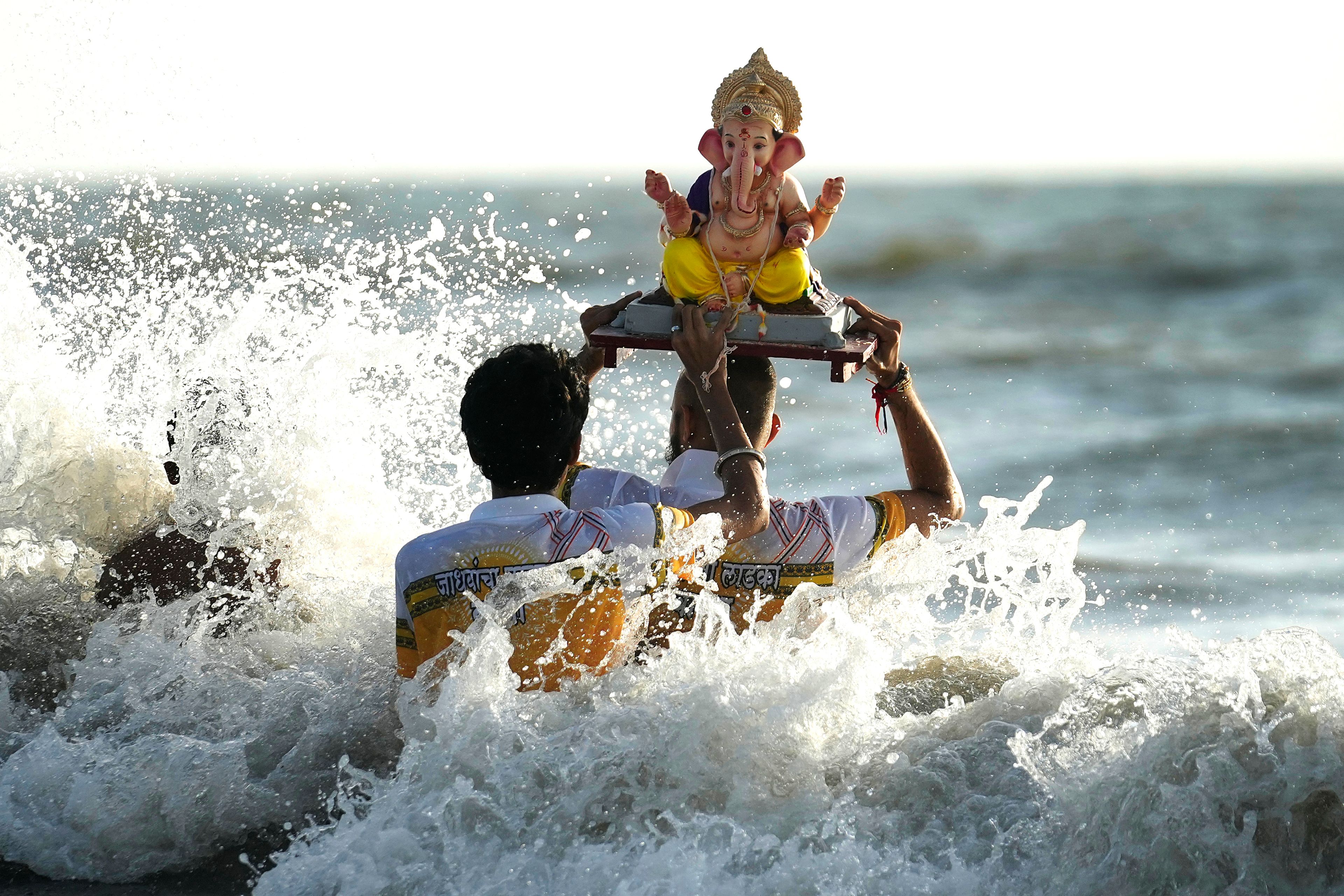 Devotees immerse an idol of elephant-headed Hindu god Ganesha in the Arabian Sea, during the ten days long Ganesh Chaturthi festival in Mumbai, India, Sunday, Sept. 8, 2024. (AP Photo/Rafiq Maqbool)