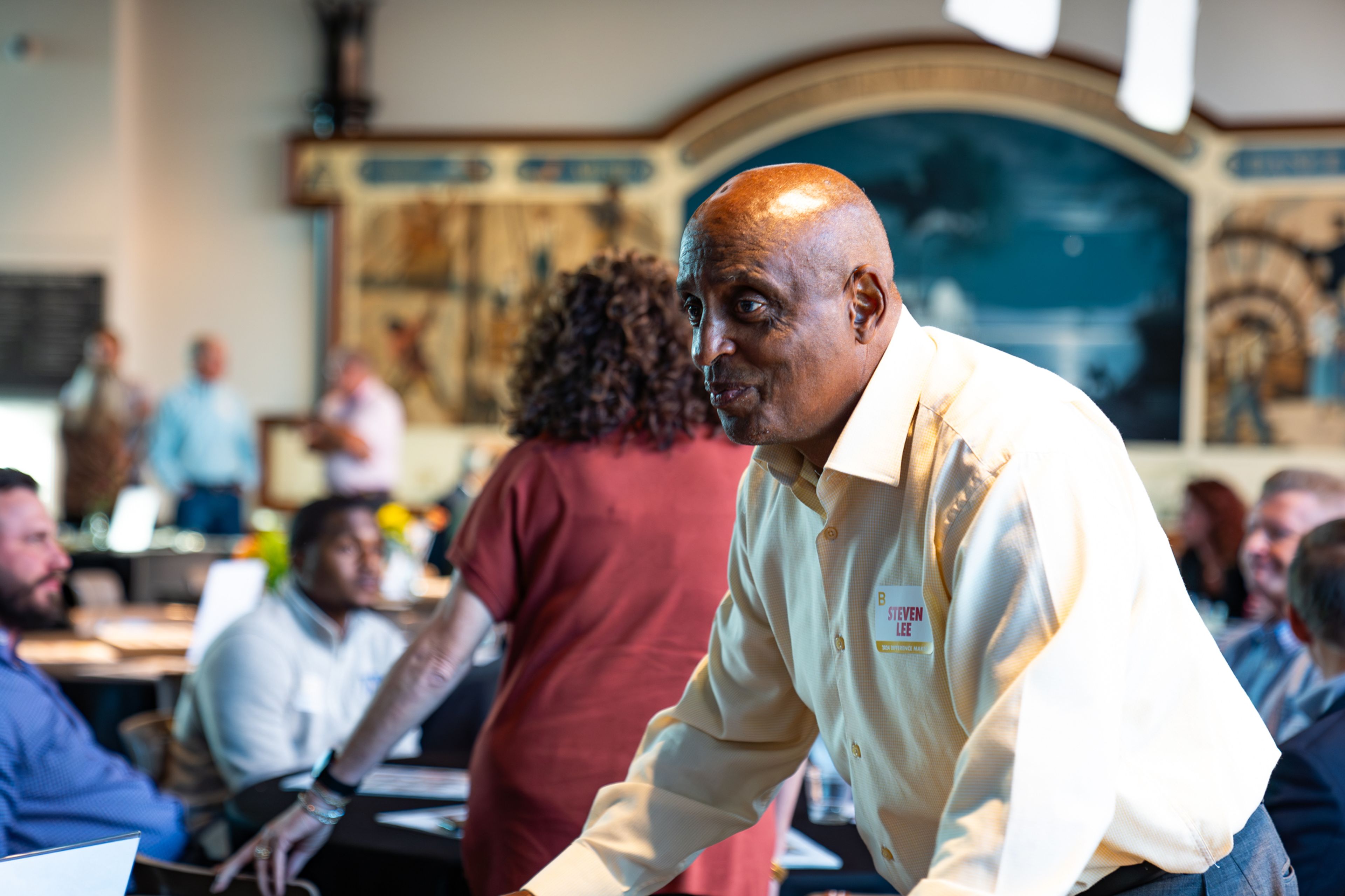 Difference Maker Steven Lee speaks to attendees at one of the tables at the reception before acknowledgments are given on Thursday, Sept. 5.