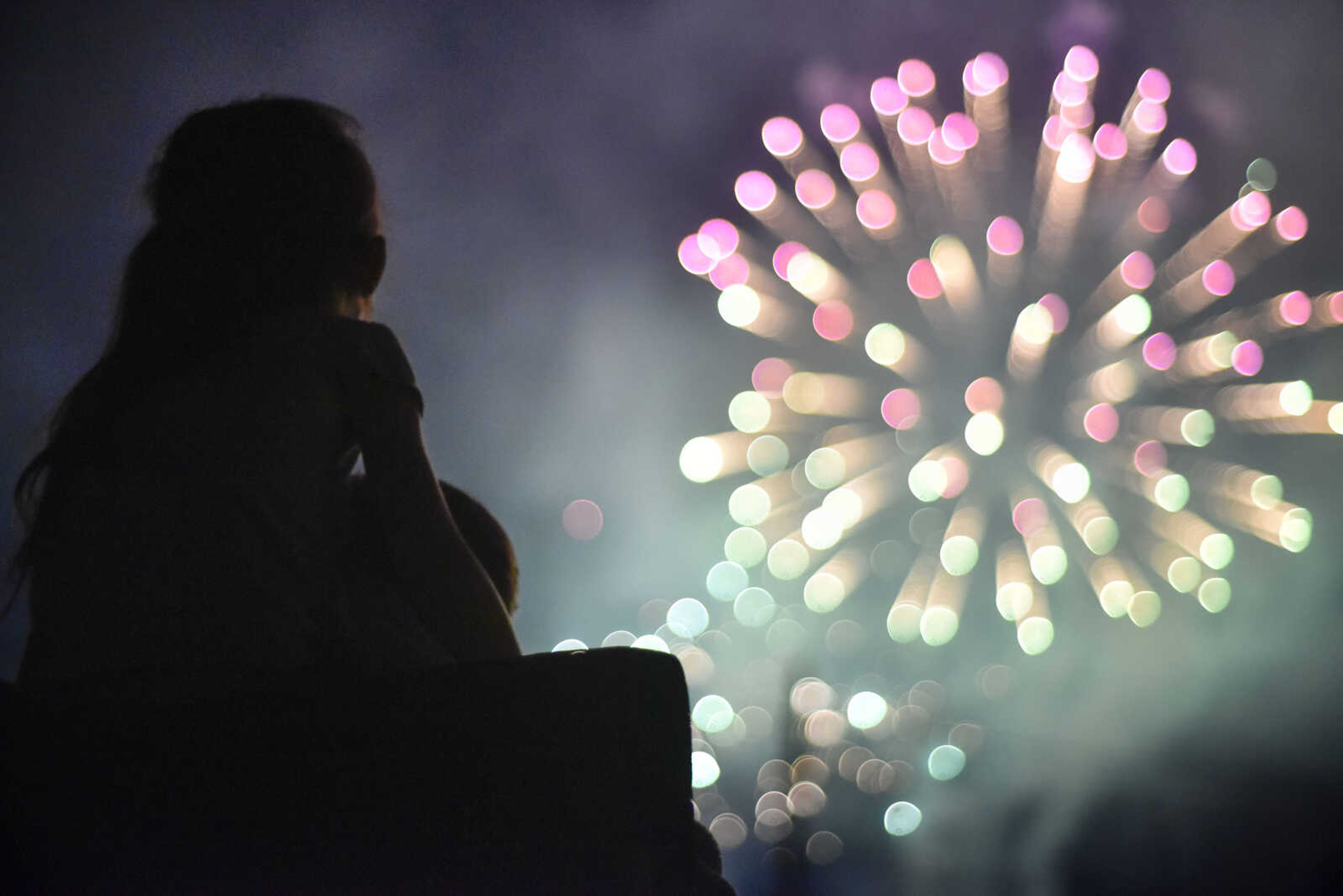 Blair, 4, watches the Missouri Veterans Home fireworks show from the Cape County Park North lawn with Kevin Stacy on Tuesday, July 3, 2018, in Cape Girardeau.