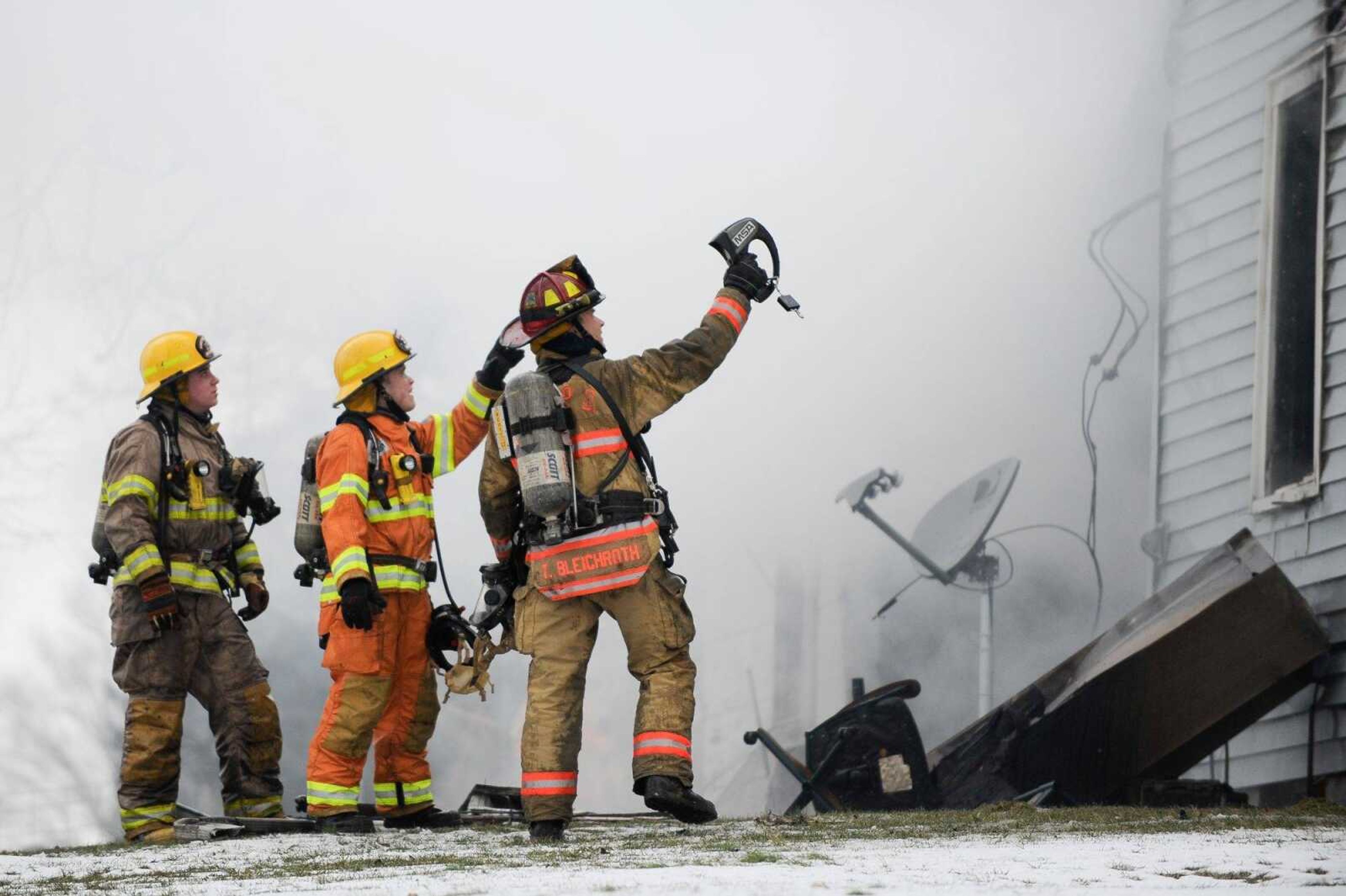 First responders use a thermal imaging camera to check for hot spots on a two-story home that caught fire Thursday, Jan. 21, 2016 near Gordonville.