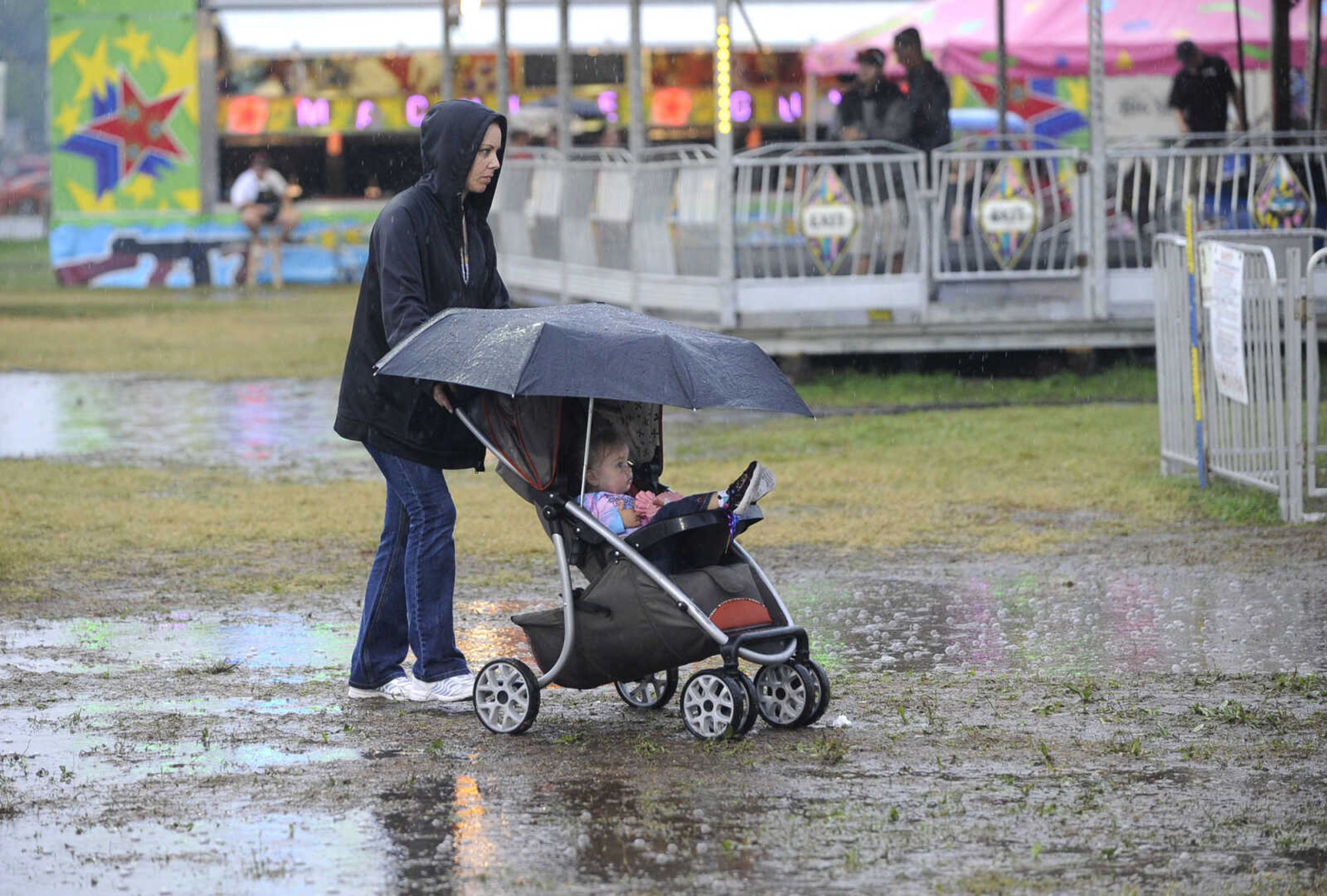 FRED LYNCH ~ flynch@semissourian.com
Christy Shackler and her daughter, Siren Handen of Cape Girardeau negotiate the soggy grounds Thursday, Sept. 15, 2016 at the SEMO District Fair in Cape Girardeau.