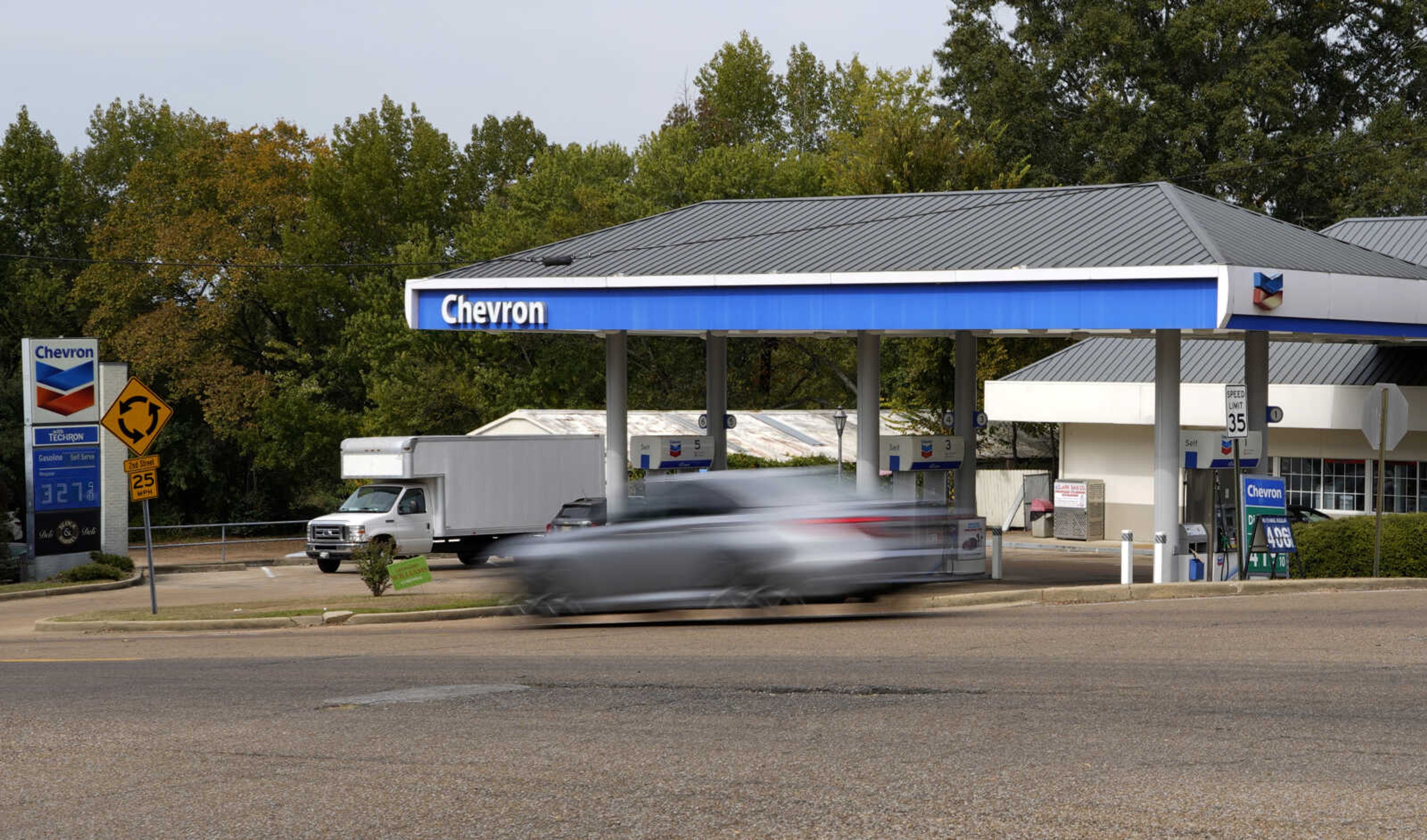 A car rolls past a Chevron station in Columbus, Miss., Monday, Oct. 23, 2023. Chevron is buying Hess Corp. for $53 billion as major producers seize the initiative while oil prices surge. (AP Photo/Rogelio V. Solis)