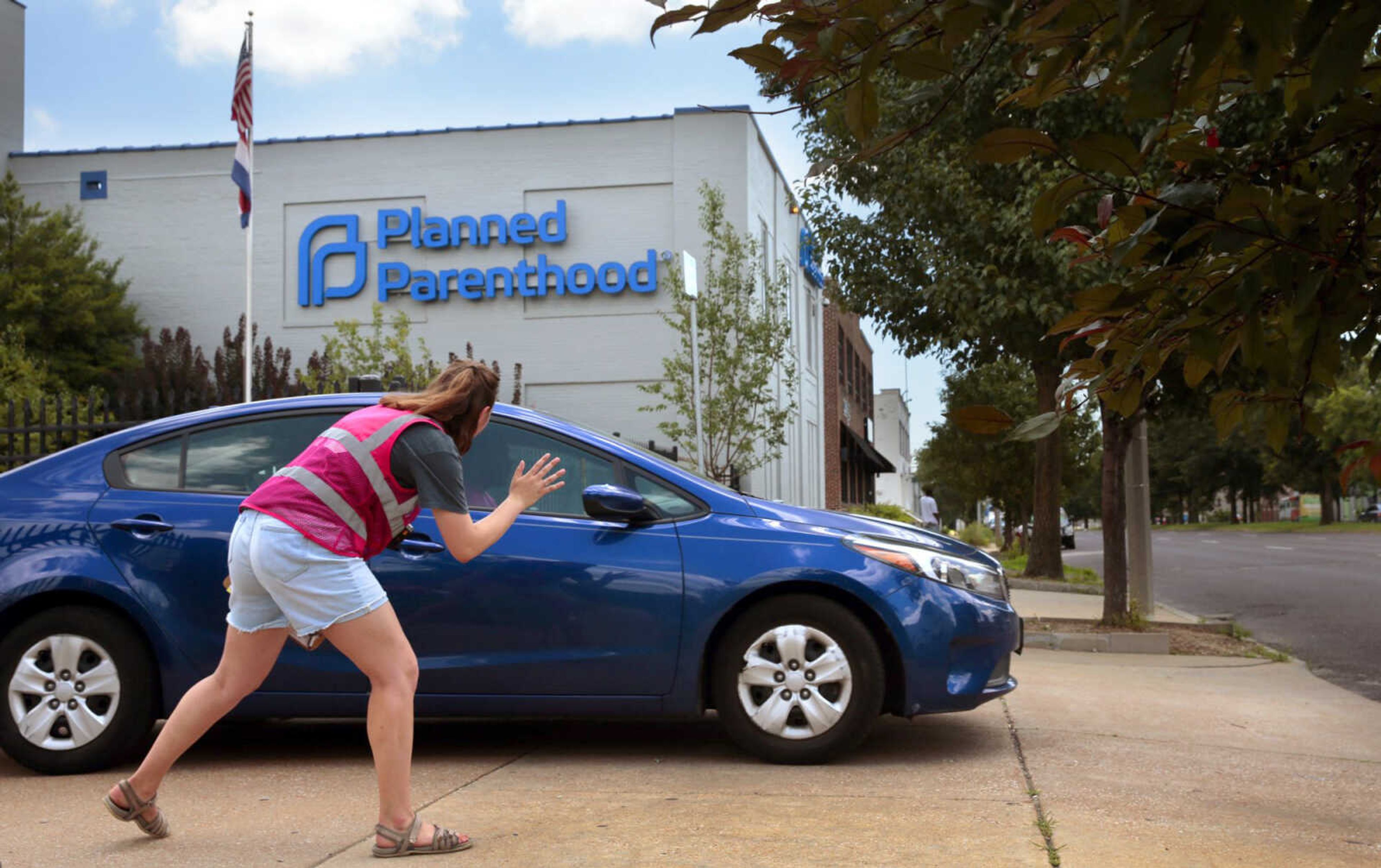 Ashlyn Myers of the Coalition for Life St. Louis waves to a Planned Parenthood staff member June 28 in St. Louis.