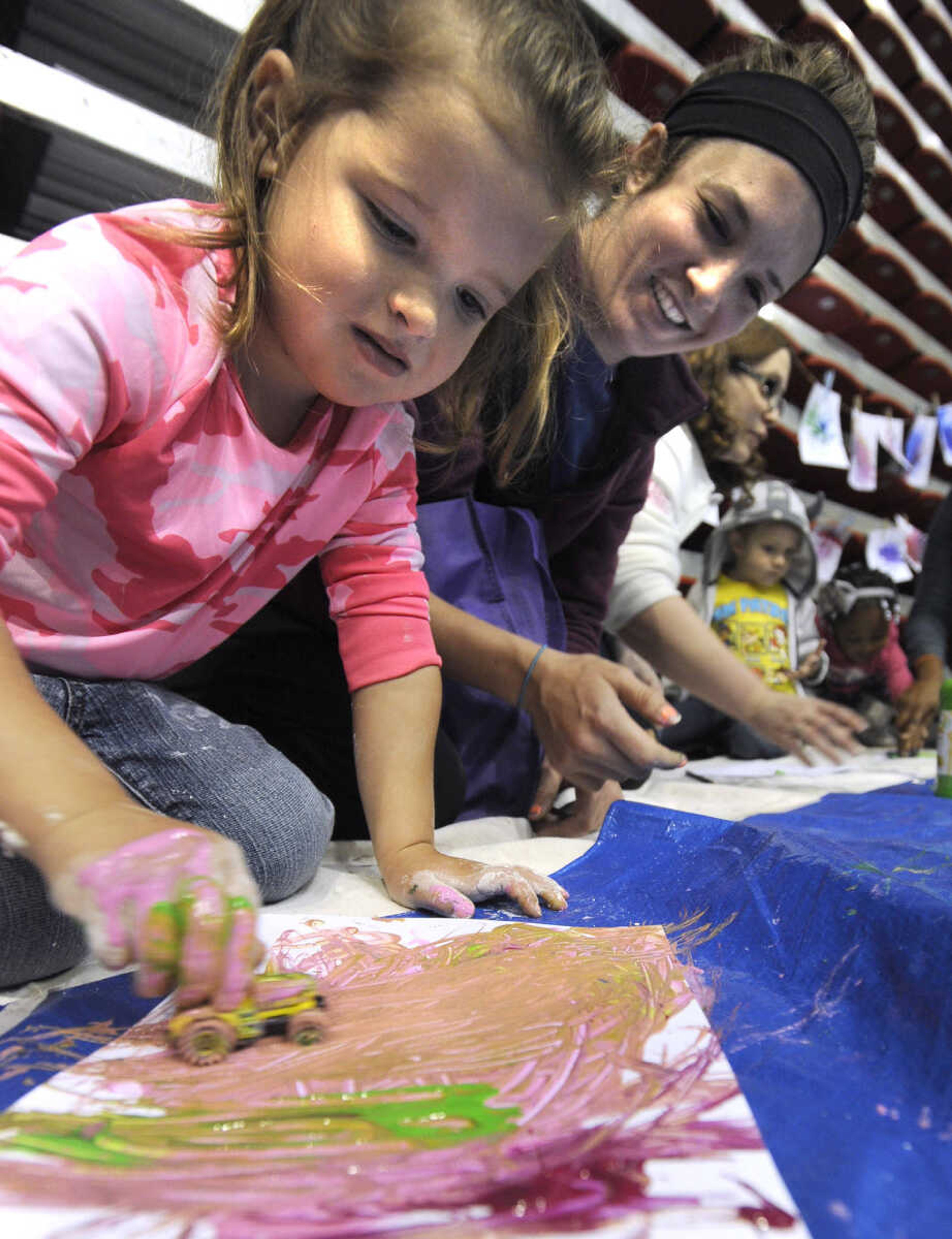 Breail Knipe, left, makes messy artwork as Jessica Betlach looks on at the Messy Morning event Saturday, April 25, 2015 at the Show Me Center.