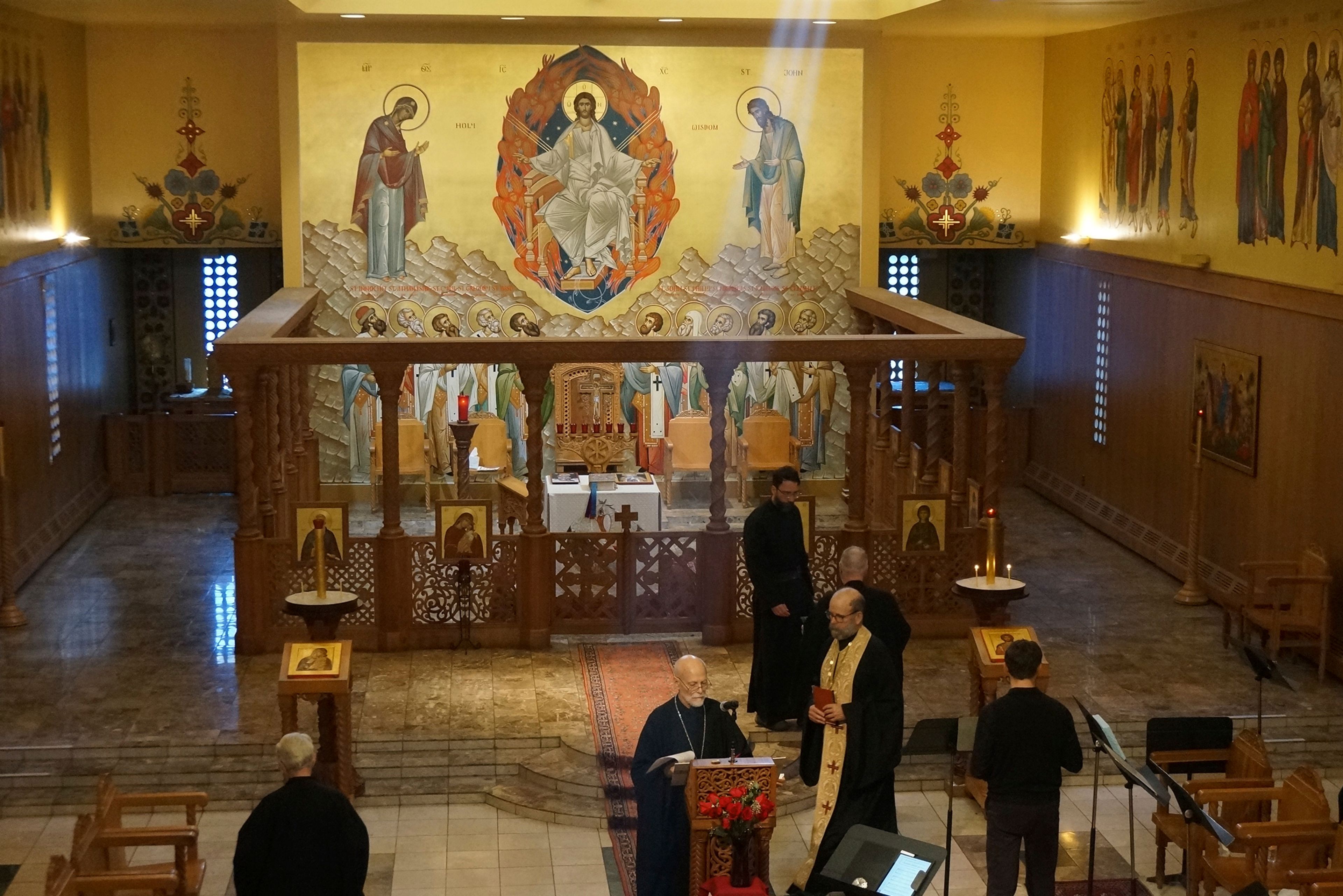 Brother Marc, center, one of the founders of the Orthodox Christian community of New Skete, and its current prior, Brother Christopher, right, holding book, finish morning prayers in the Church of Holy Wisdom, the larger of two churches of the monastery renowned for dog breeding and training programs outside Cambridge, N.Y., on Oct. 12, 2024. (AP Photo/Giovanna Dell’Orto)