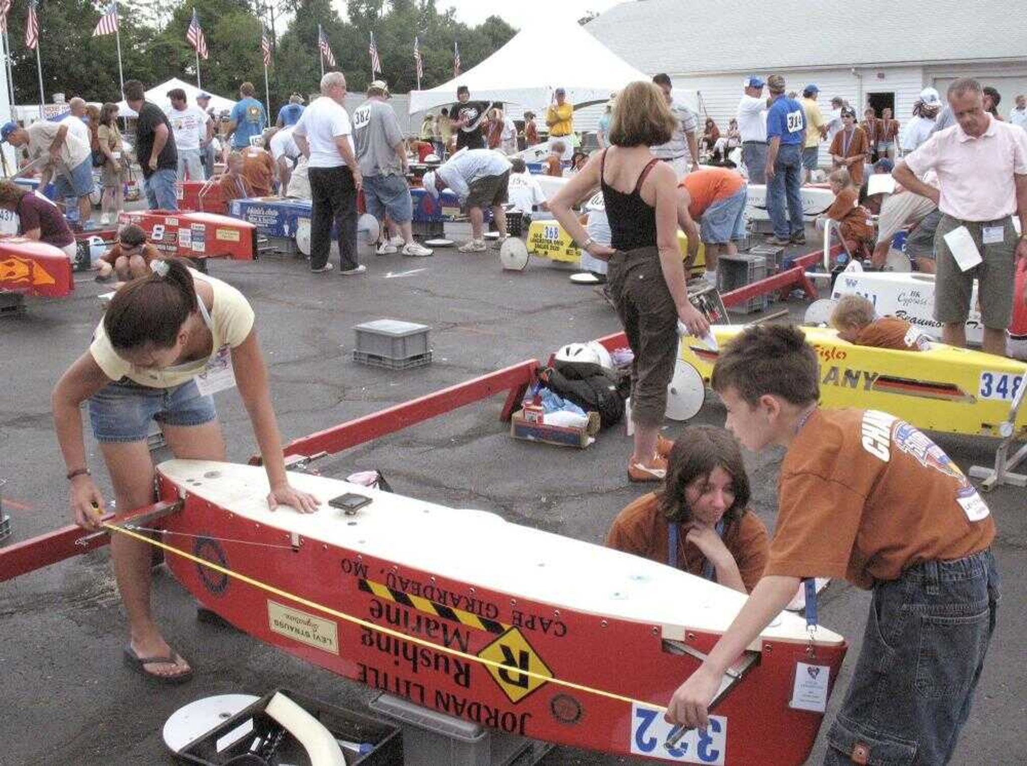 April, Jordan and Beth Little measured the distance between the rear and front axles on Jordan's Soap Box Derby racer Wednesday. The process, known as triangulation, confirms proper alignment of the car. (PETER WYLIE ~ pwylie@semissourian.com)