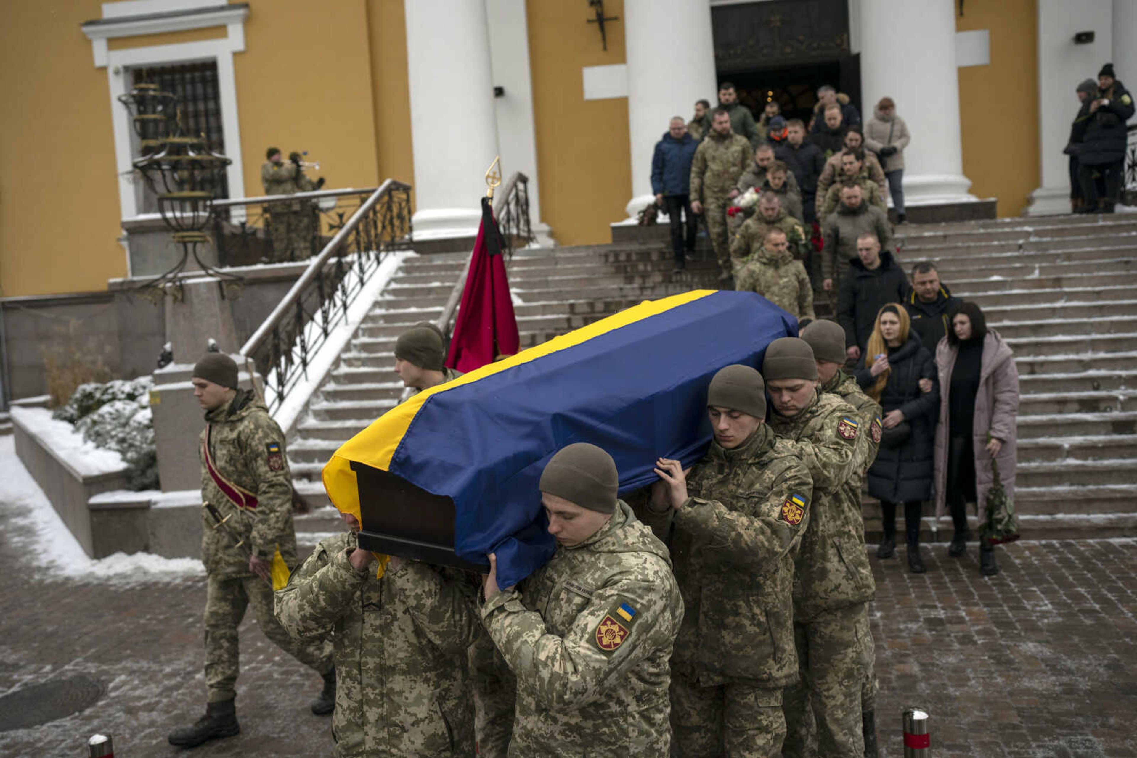 Soldiers carry the coffin of Eduard Strauss, a Ukrainian serviceman who died in combat Jan. 17 in Bakhmut, during a farewell ceremony Monday in Kyiv, Ukraine.