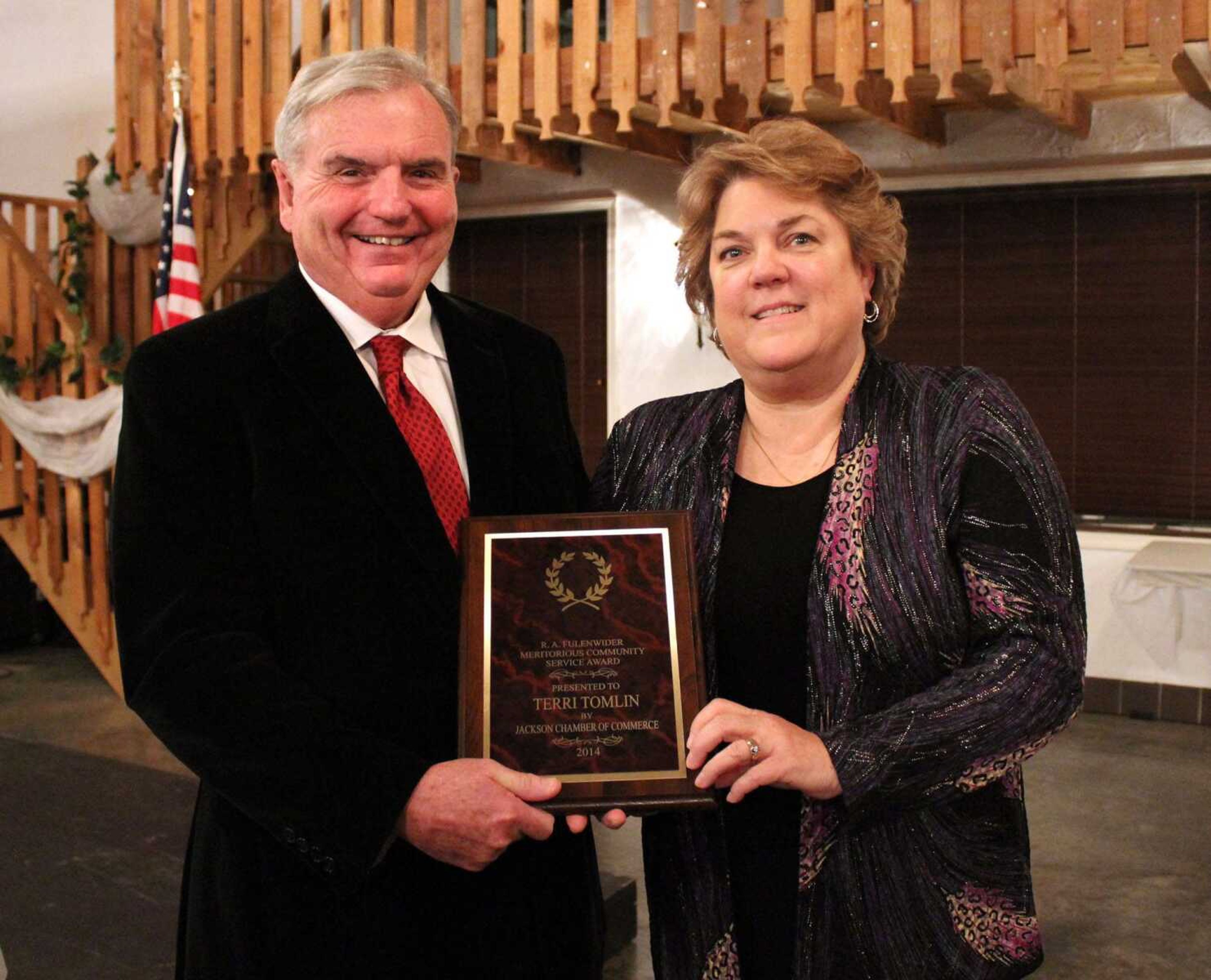 Terri Tomlin accepts the 2015 R.A. Fulenwider Meritorious Community Service Award from Dwight Johnson at the Jackson Area Chamber of Commerce annual banquet.