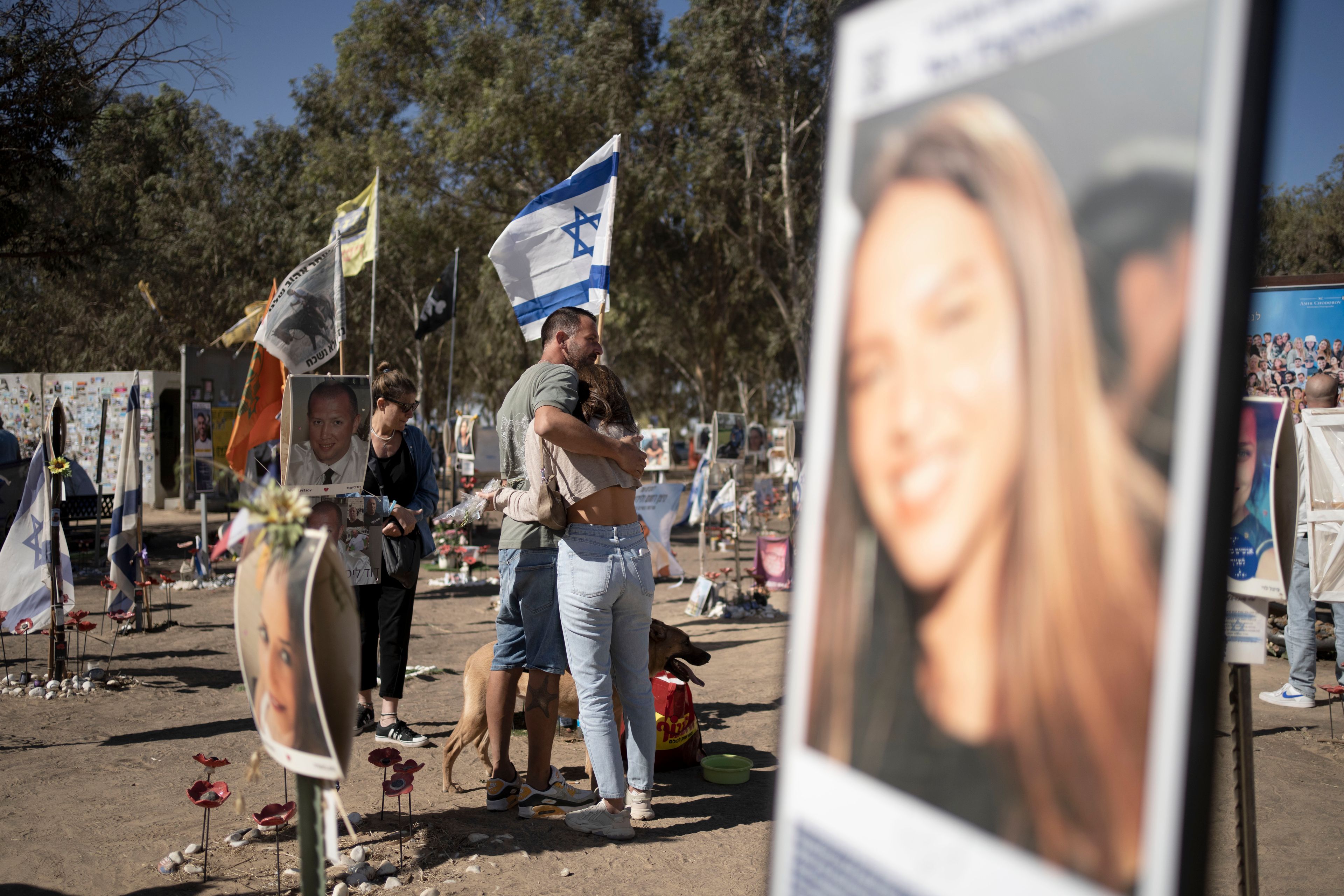 A family visits the the memorial marker of their loved one, Bar Lior Nakmuli, at the site of the Nova music festival, where hundreds of revelers were killed or kidnapped by Hamas, on the Jewish holiday of Simchat Torah, marking one year in the Hebrew calendar since the attack, near Kibbutz Re'im, southern Israel near the Gaza Strip, Thursday, Oct. 24, 2024. (AP Photo/Maya Alleruzzo)