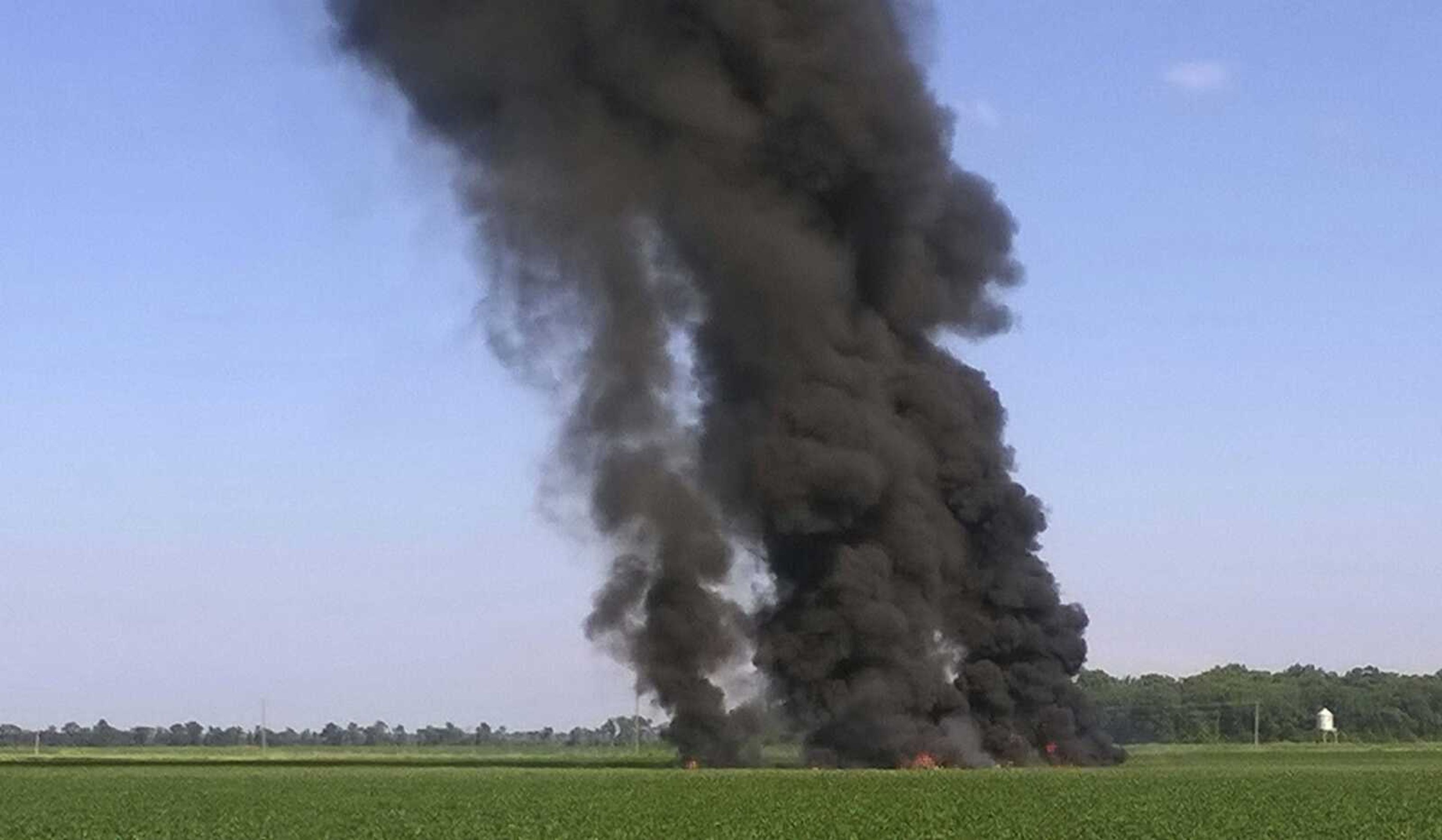 Smoke and flames rise into the air after a military transport airplane crashed Monday in a field near Itta Bena, Mississippi.