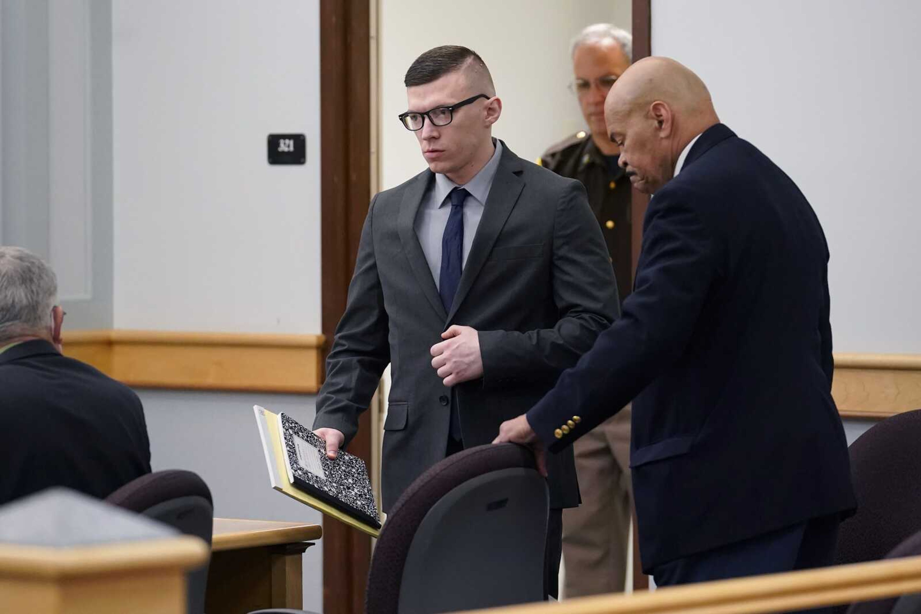 Volodymyr Zhukovskyy of West Springfield, Massachusetts, center, charged with negligent homicide in the deaths of seven motorcycle club members in a 2019 crash, enters a courtroom at Coos County Superior Court on July 25 in Lancaster, New Hampshire.