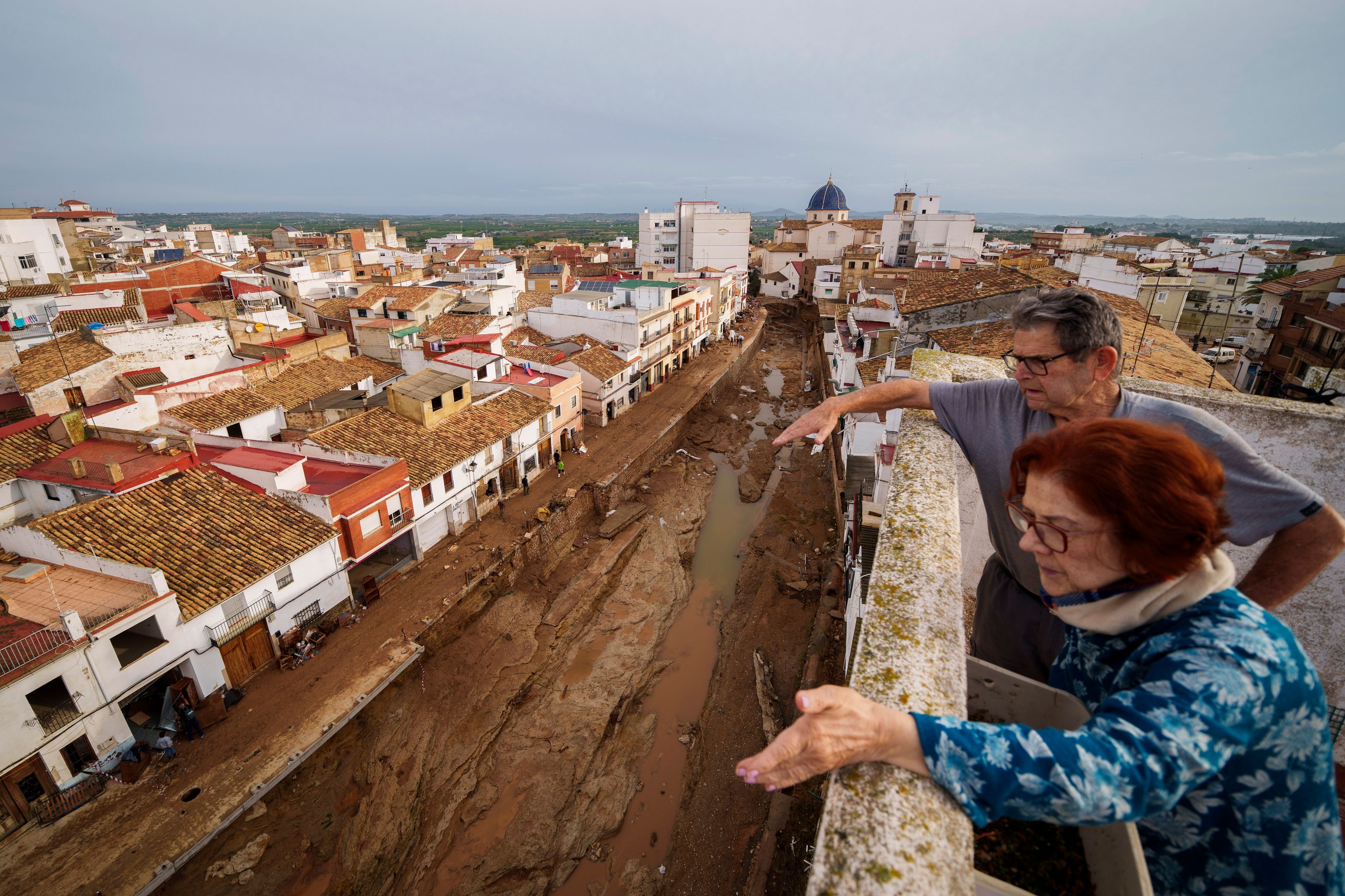 Two people look out over an area affected by floods in Chiva, Spain, Friday, Nov. 1, 2024. (AP Photo/Manu Fernandez)