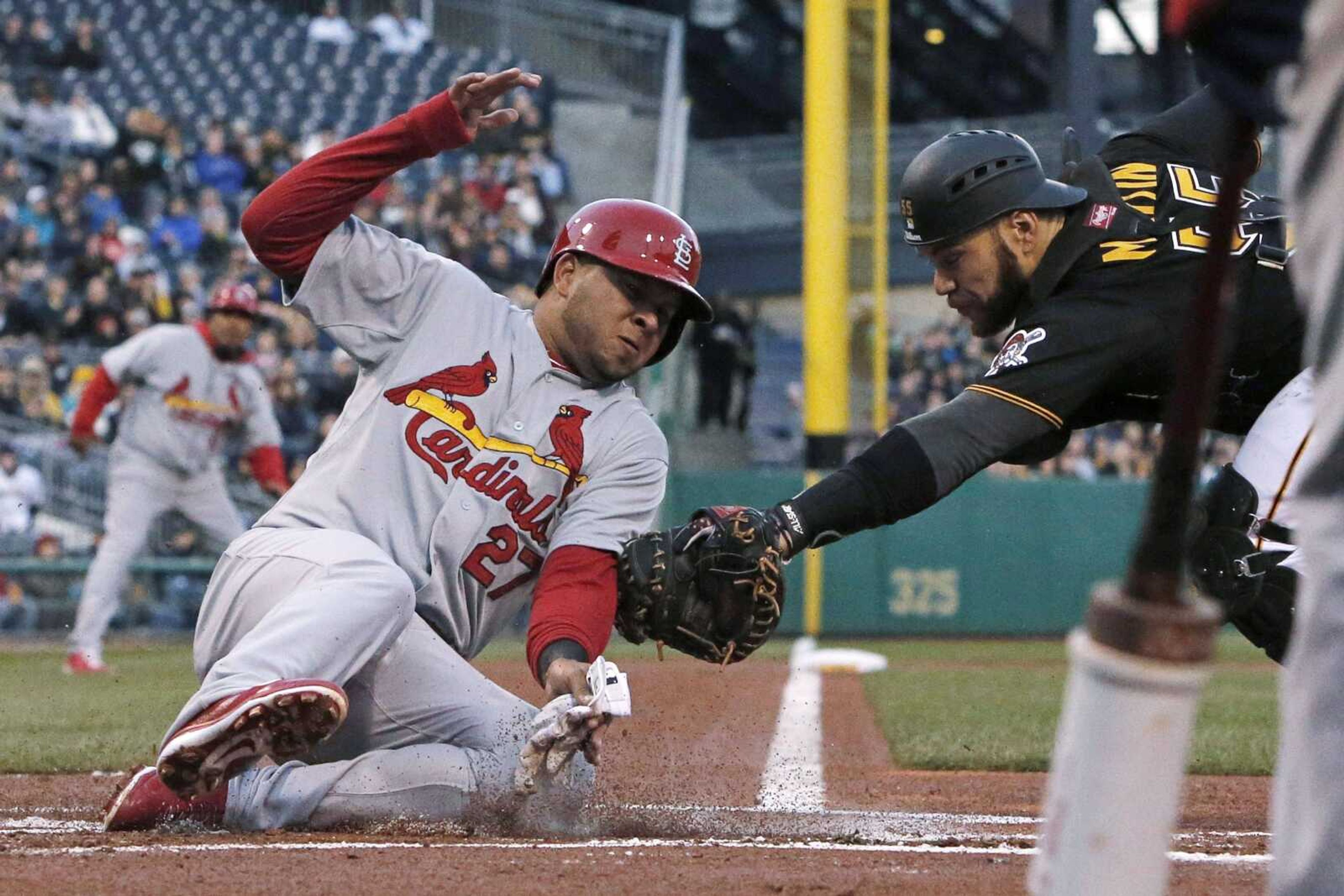 St. Louis Cardinals&#8217; Jhonny Peralta slides safely around the attempted tag by Pittsburgh Pirates catcher Russell Martin Saturday in Pittsburgh. (Gene J.Puskar ~ Associated Press)