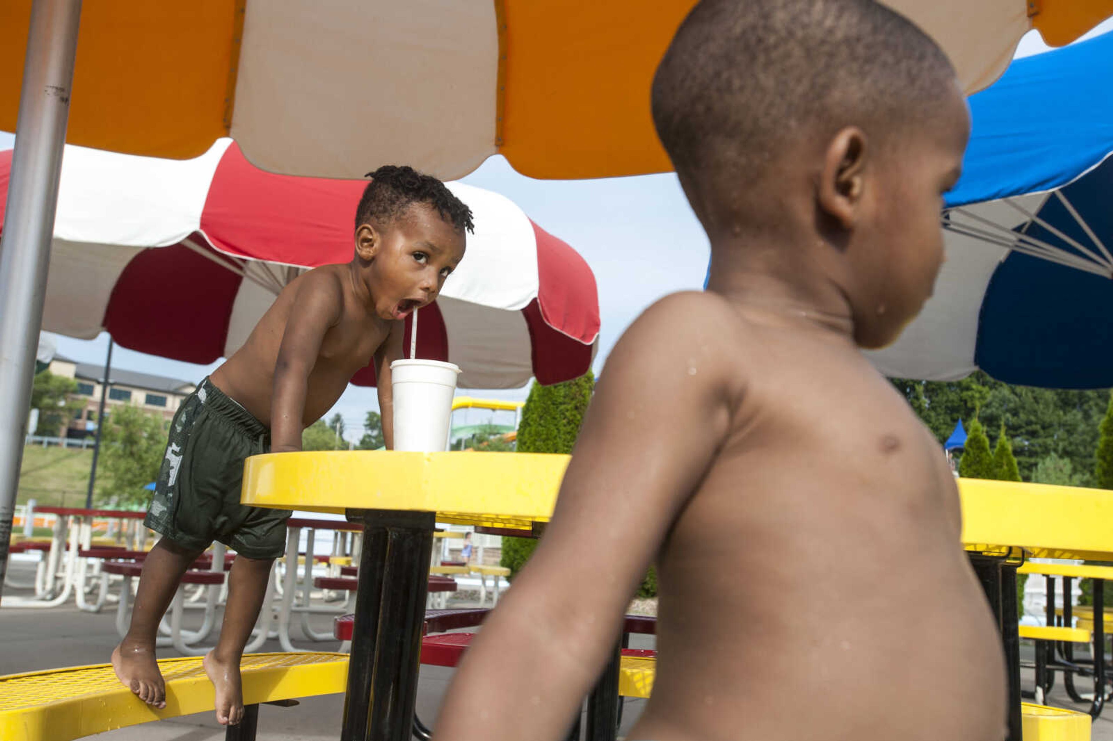 Tyson Mack, 2, takes a drink of his father's soda while his brother, Tylan, 4, looks away Sunday, Aug. 11, 2019, at Cape Splash in Cape Girardeau.